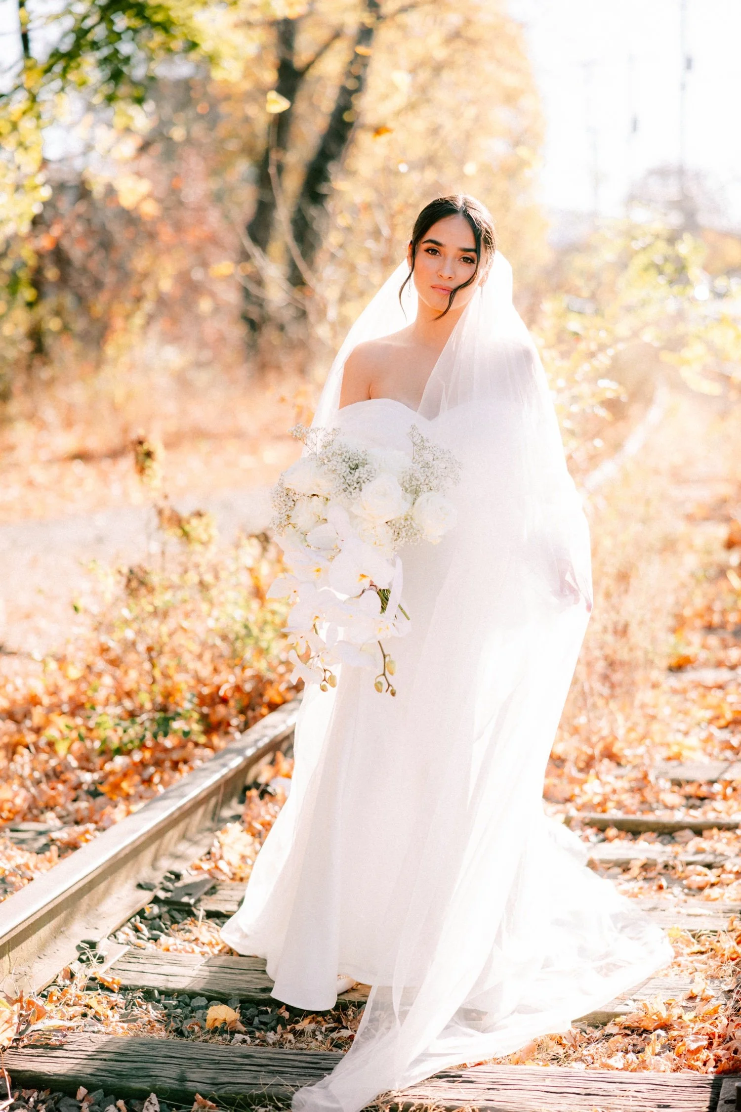 editorial photograph of bride on the train tracks on her wedding day at the roundhouse