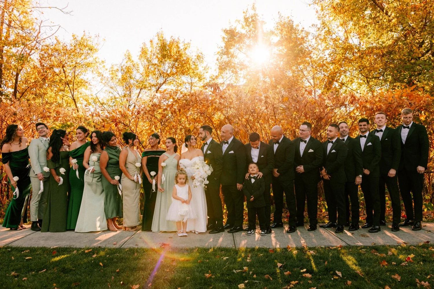 wedding party standing in front of autumn foliage at the roundhouse