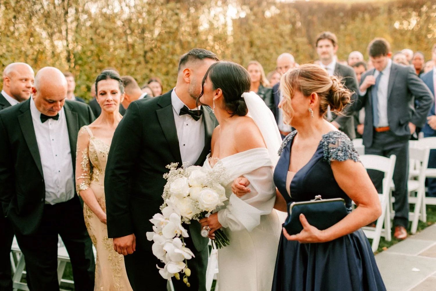 bride kisses her brother on the cheek as he gives her away during her autumn wedding ceremony at the roundhouse