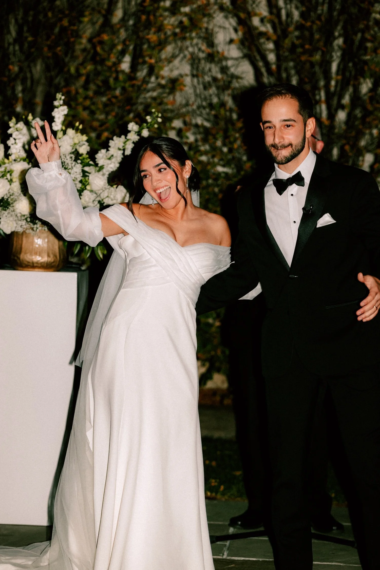 bride smiles and waves to guests at wedding ceremony outside the roundhouse