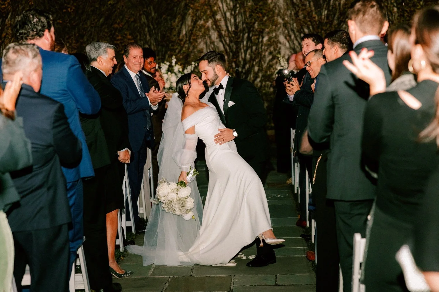 groom dips bride in the aisle during their november wedding ceremony at the roundhouse