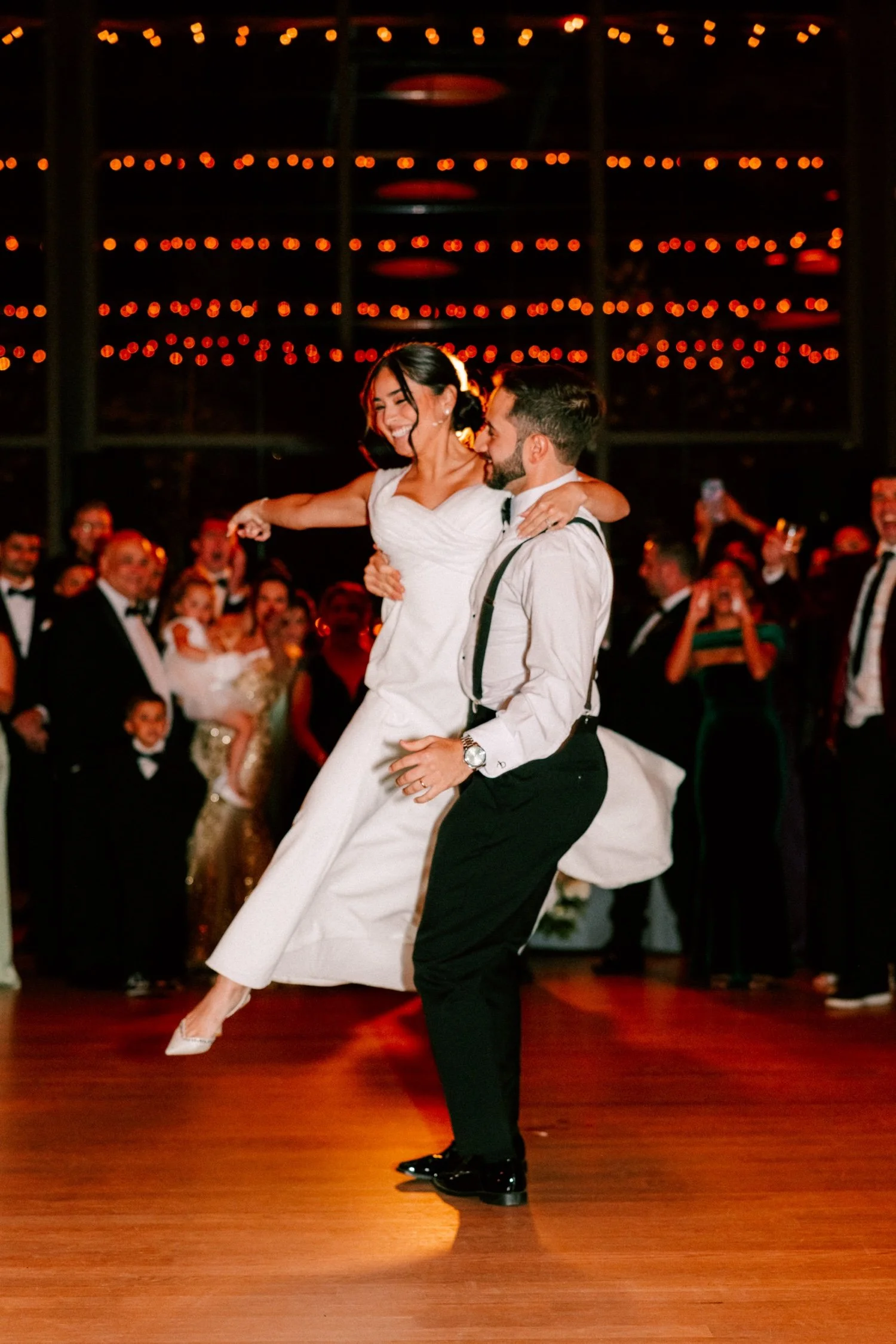 grooms lifts bride during first dance at the roundhouse