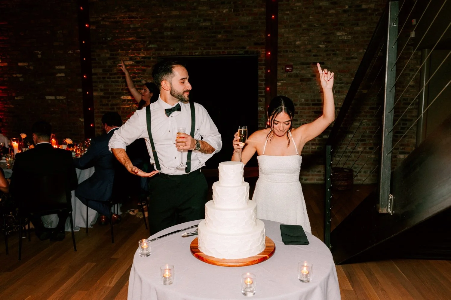 bride and groom celebrate after cutting their cake at the roundhouse