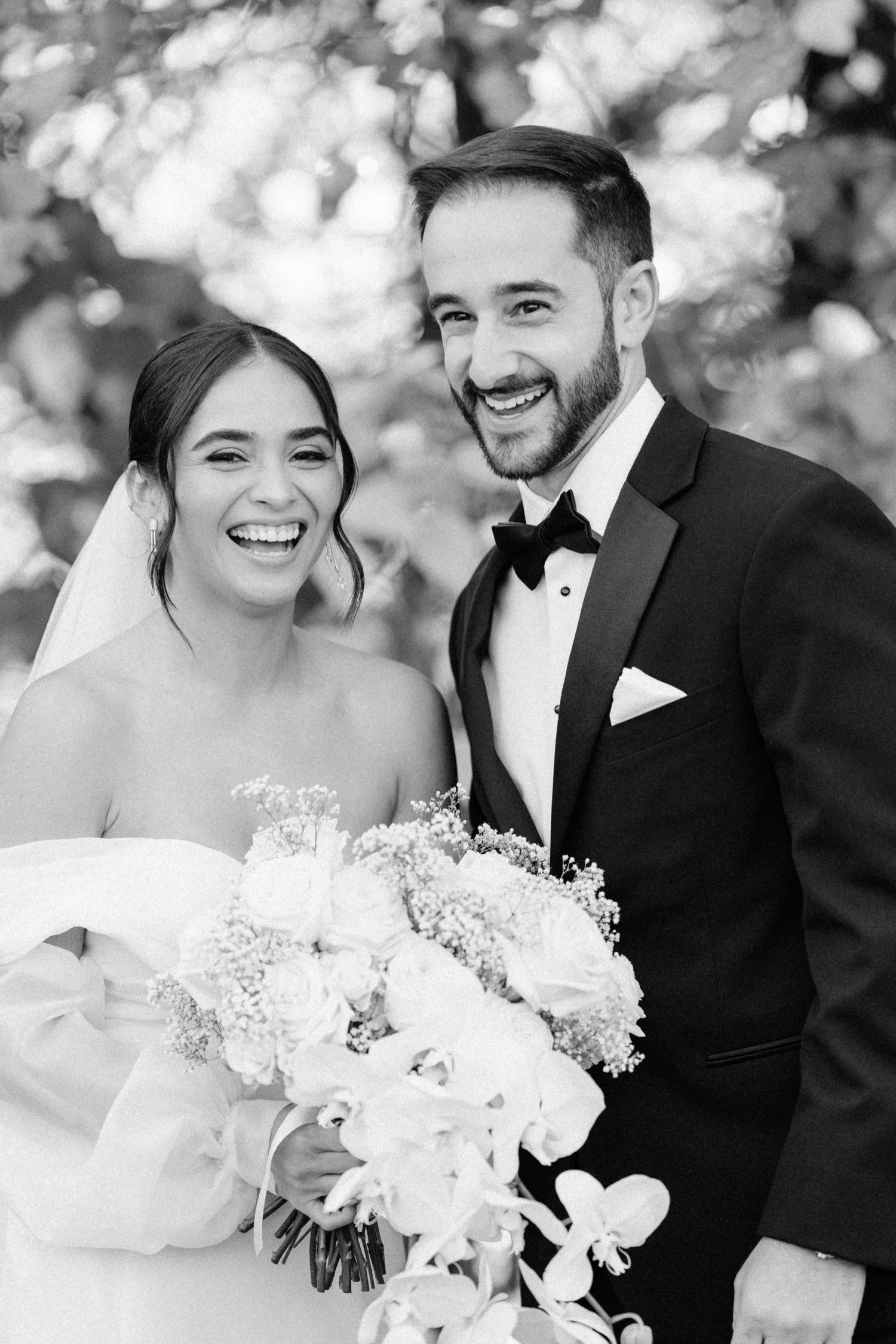 documentary black and white photograph of bride and groom laughing on their wedding day at the roundhouse