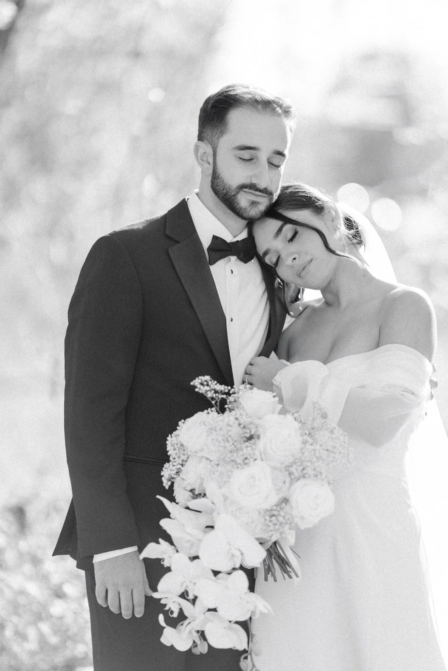 timeless black and white photograph of bride and groom cuddling on their wedding day at the roundhouse