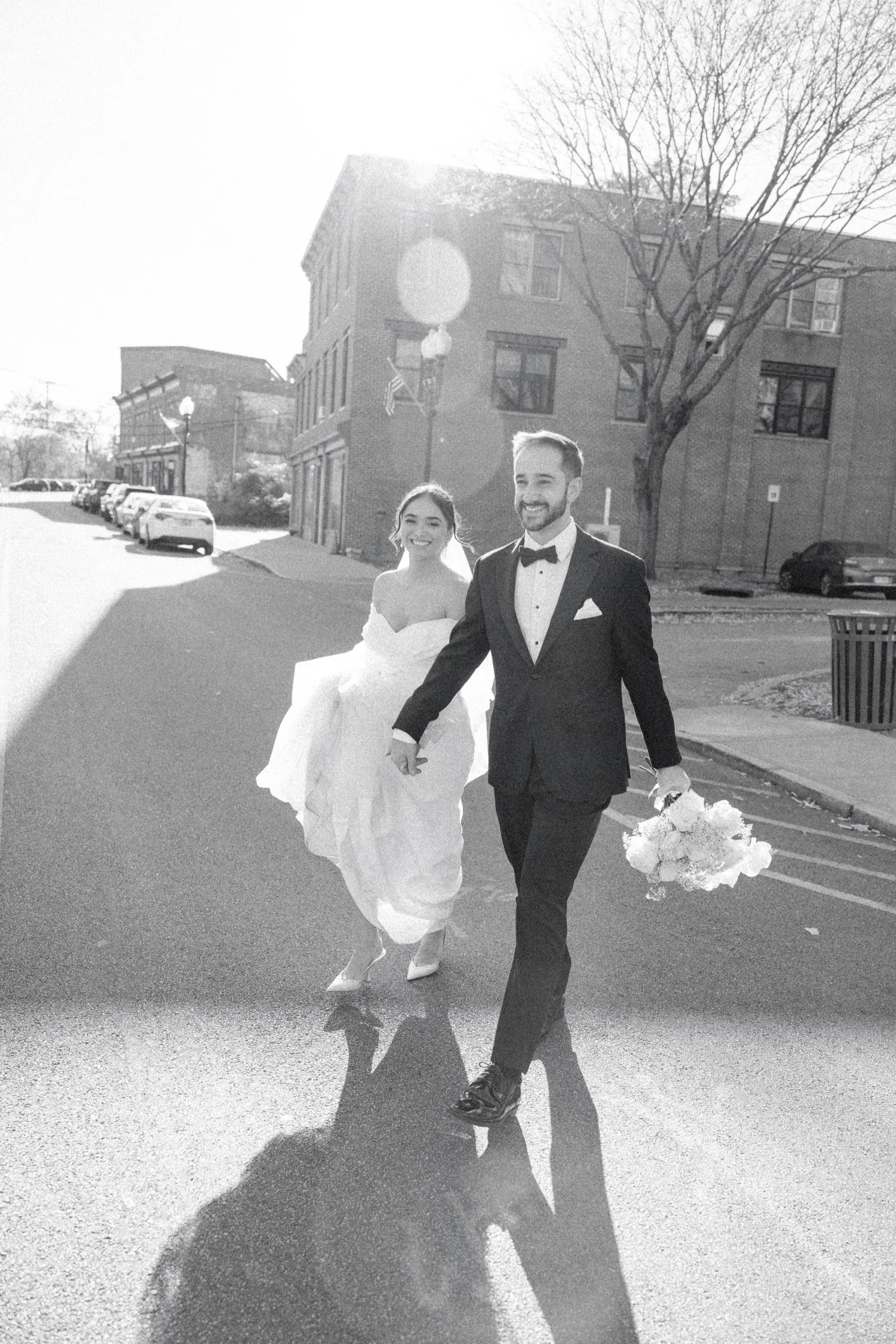 documentary black and white photograph of wedding couple walking across the street in beacon ny