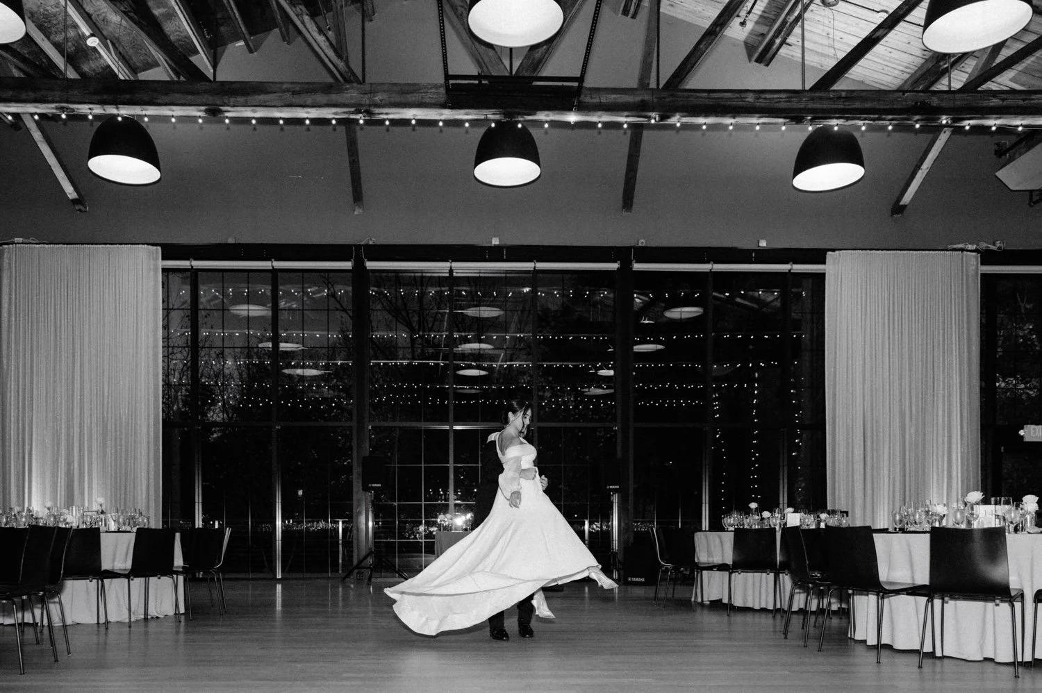 black and white photograph of bride and groom practicing first dance at the roundhouse