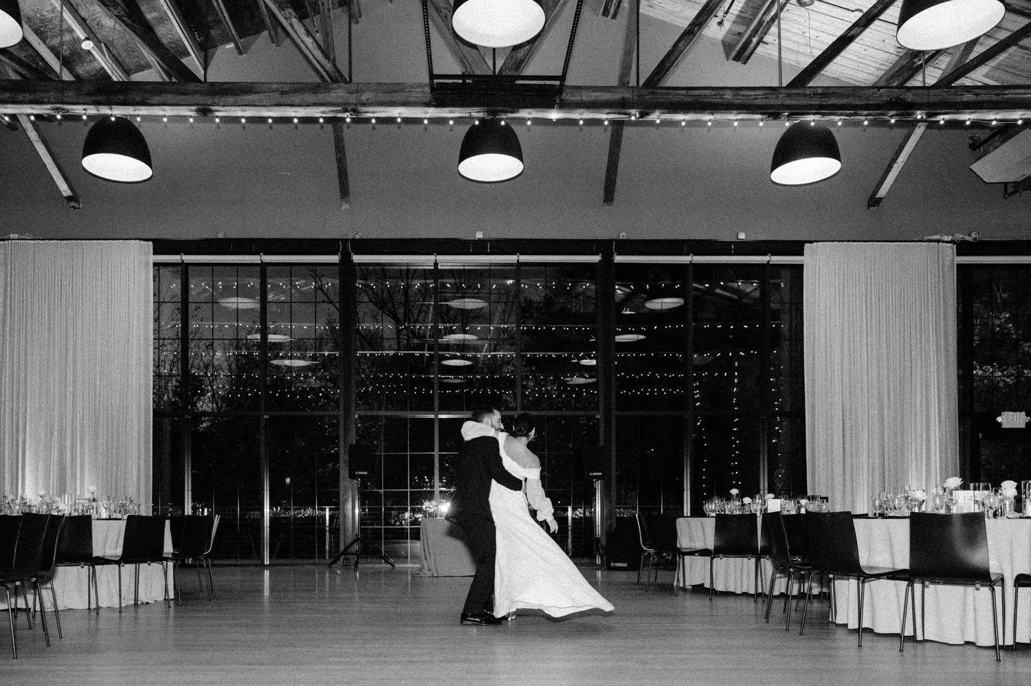 black and white photograph of bride and groom dancing during room reveal on wedding day at the roundhouse