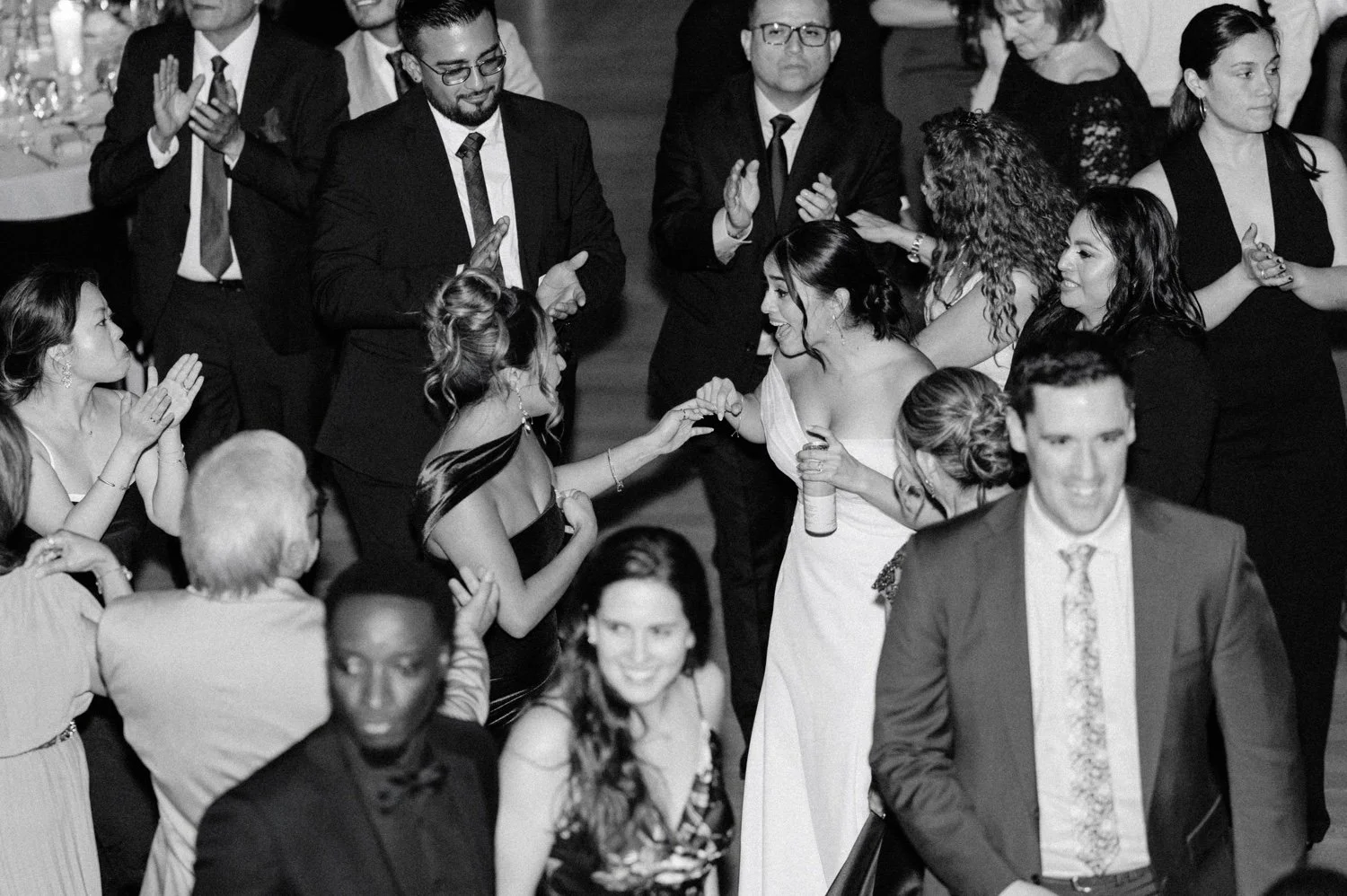 black and white photographs of bride and maid of honor dancing during reception at the roundhouse