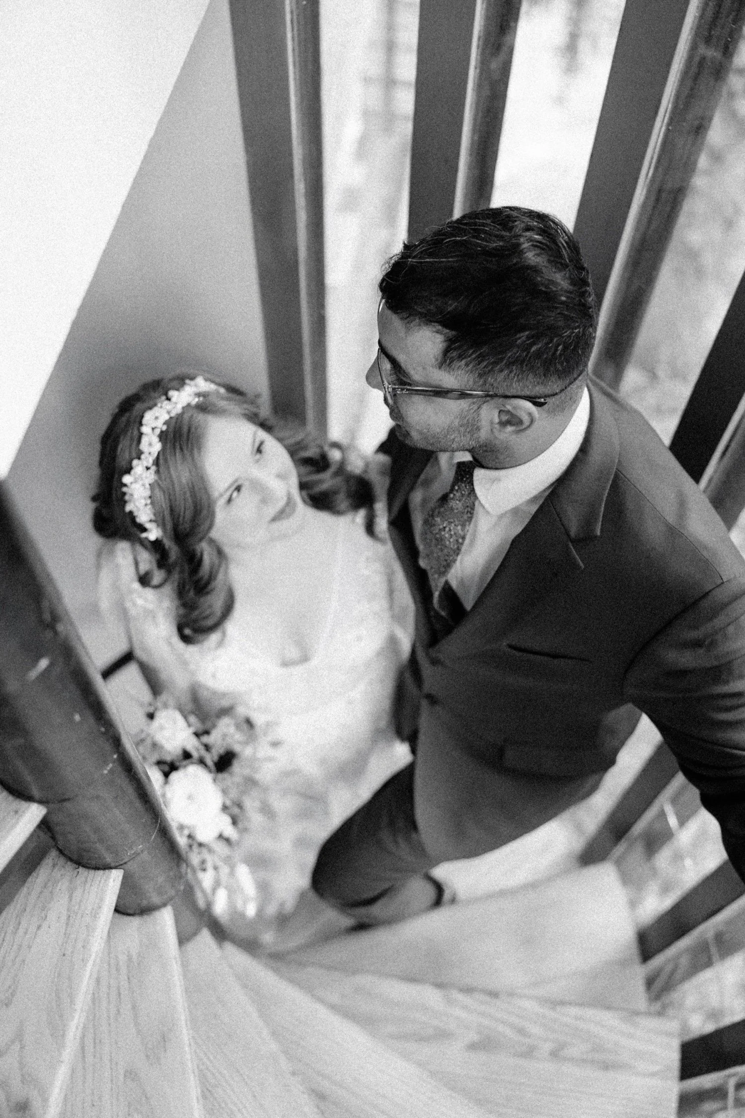 black and white photograph of bride and groom on the spiral staircase in ponys pad at Buttermilk Falls Inn and Spa