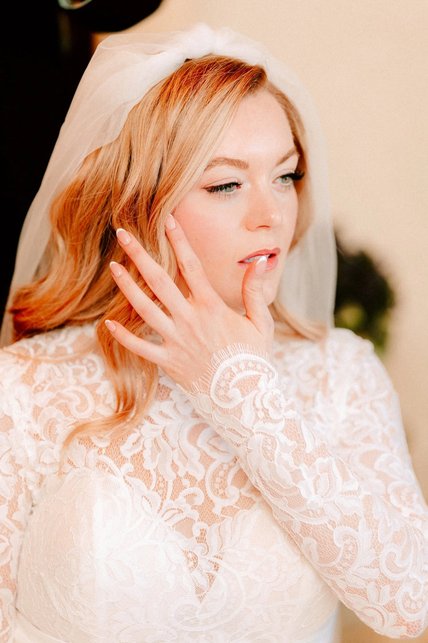 bride moving hair aside while veil is being put on for winter wedding day at the ashford estate