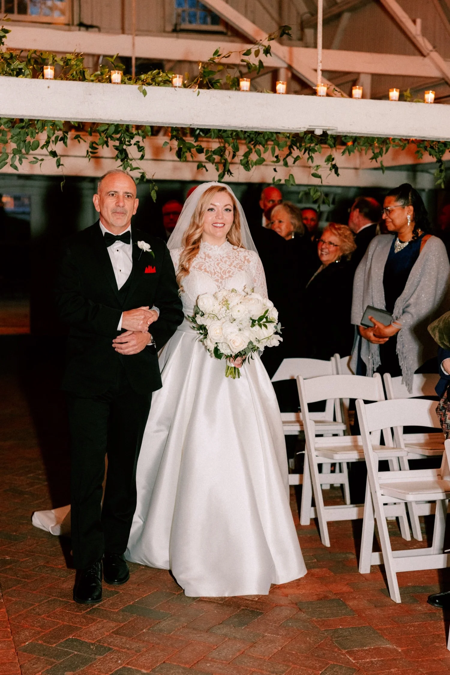 bride walking down the aisle during wedding ceremony in the barn at the ashford estate