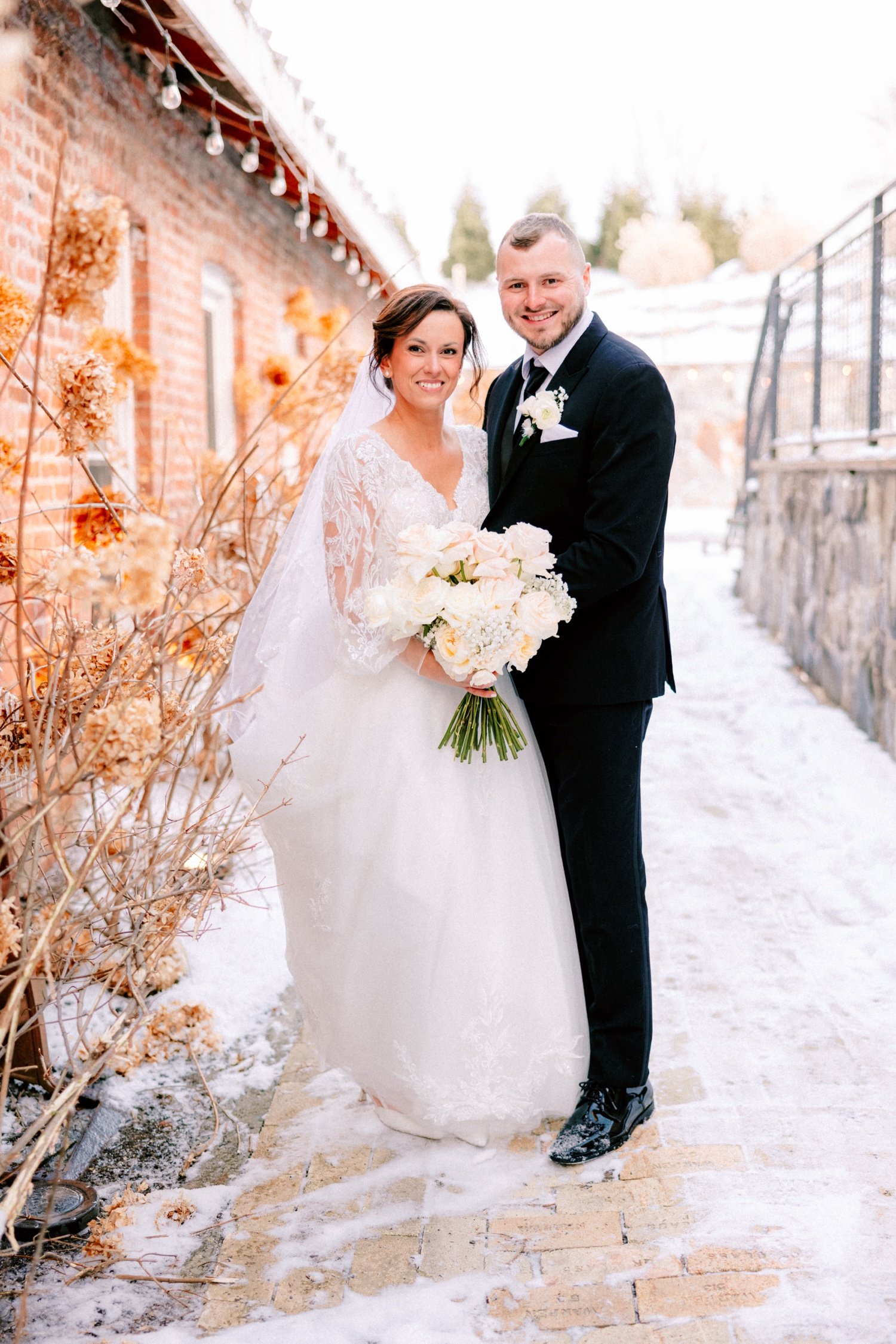  winter wedding couple pose for photos in the snow outside City Winery Hudson Valley 