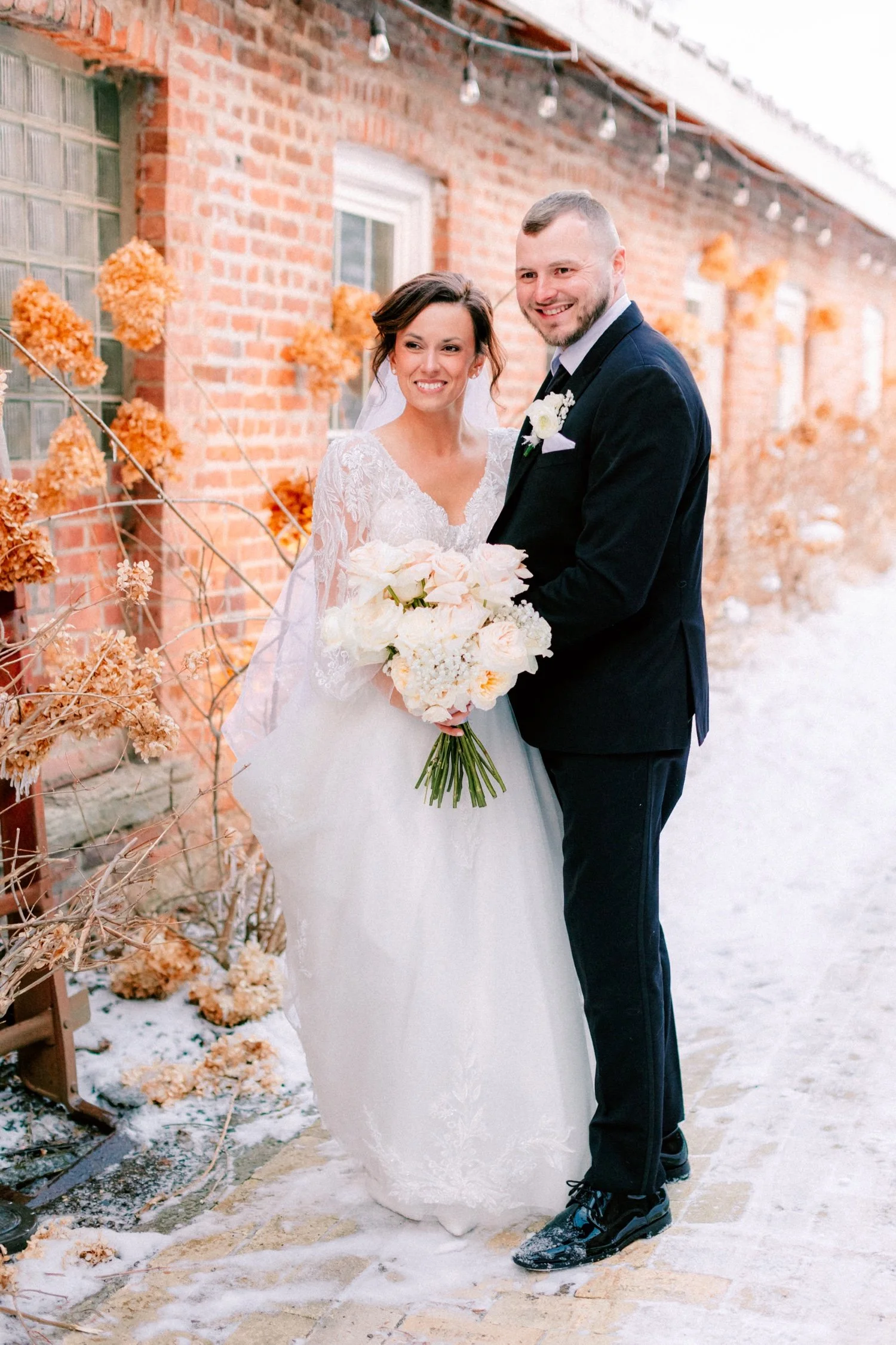  winter wedding couple pose for photos in the snow outside City Winery Hudson Valley 