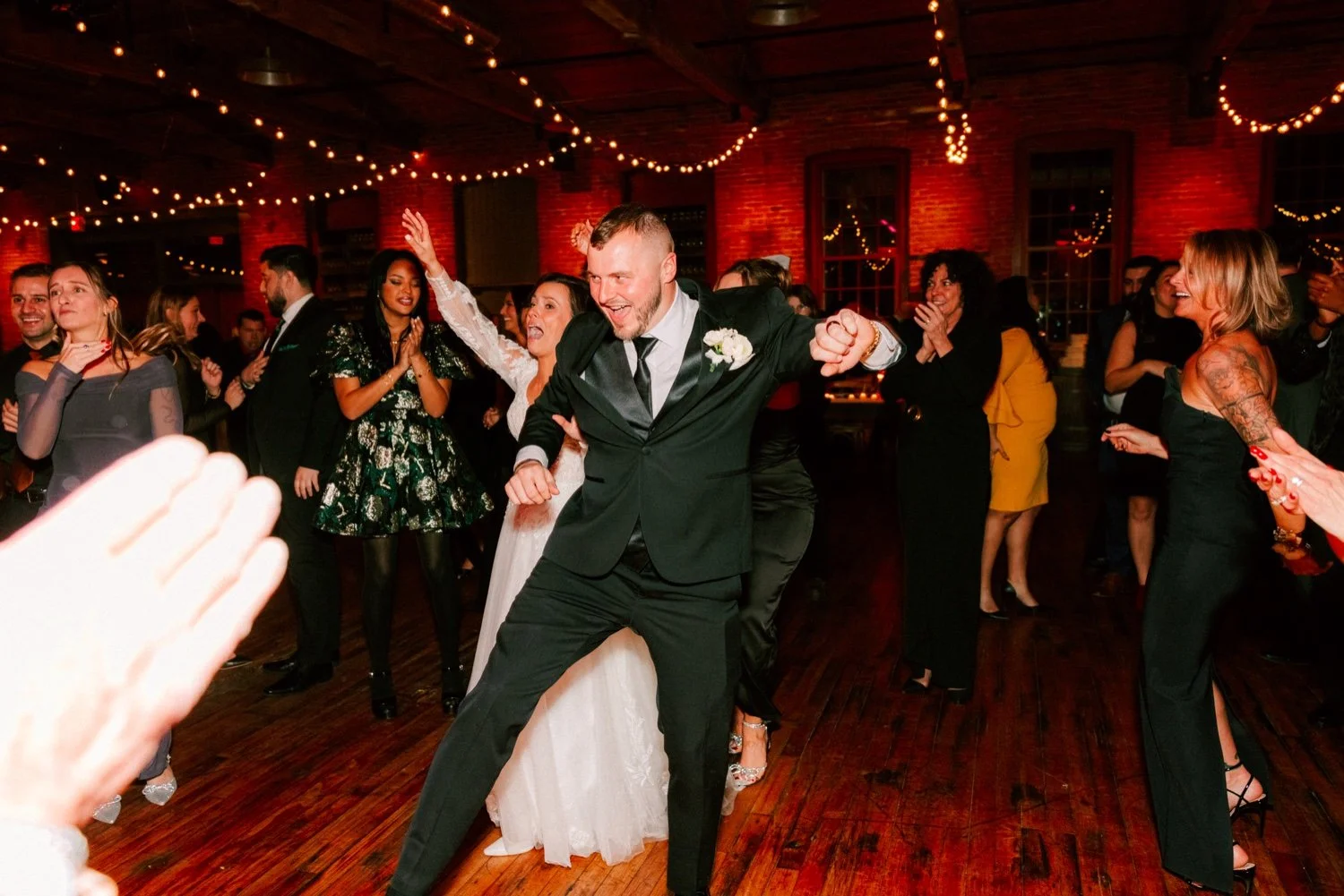  bride and groom dancing in crowd of guests during their wedding reception at city winery hudson valley 