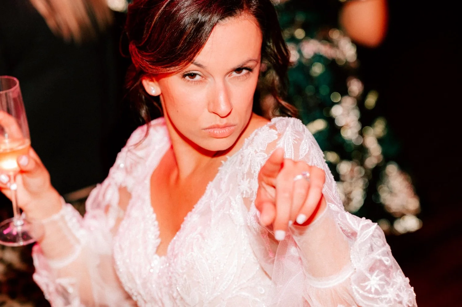  bride pointing at the camera while holding a glass of champagne during her winter wedding reception at city winery hudson valley 