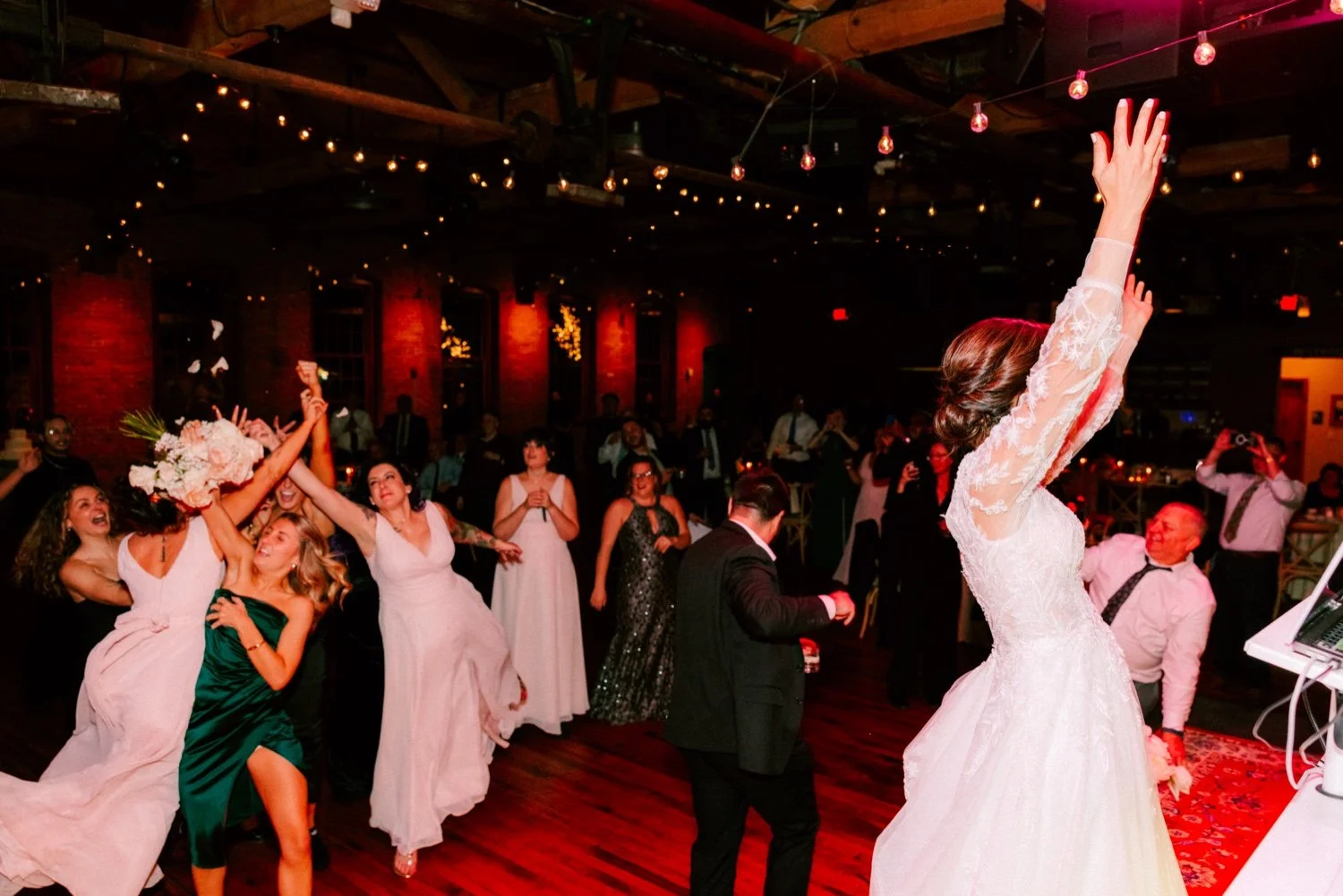 chaotic and wild bouquet toss during winter wedding reception at city winery hudson valley 