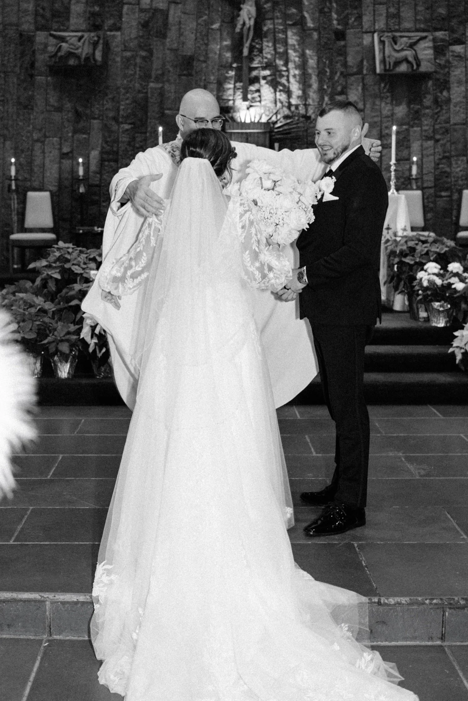  wedding couple hug priest after their church ceremony in newburgh ny 
