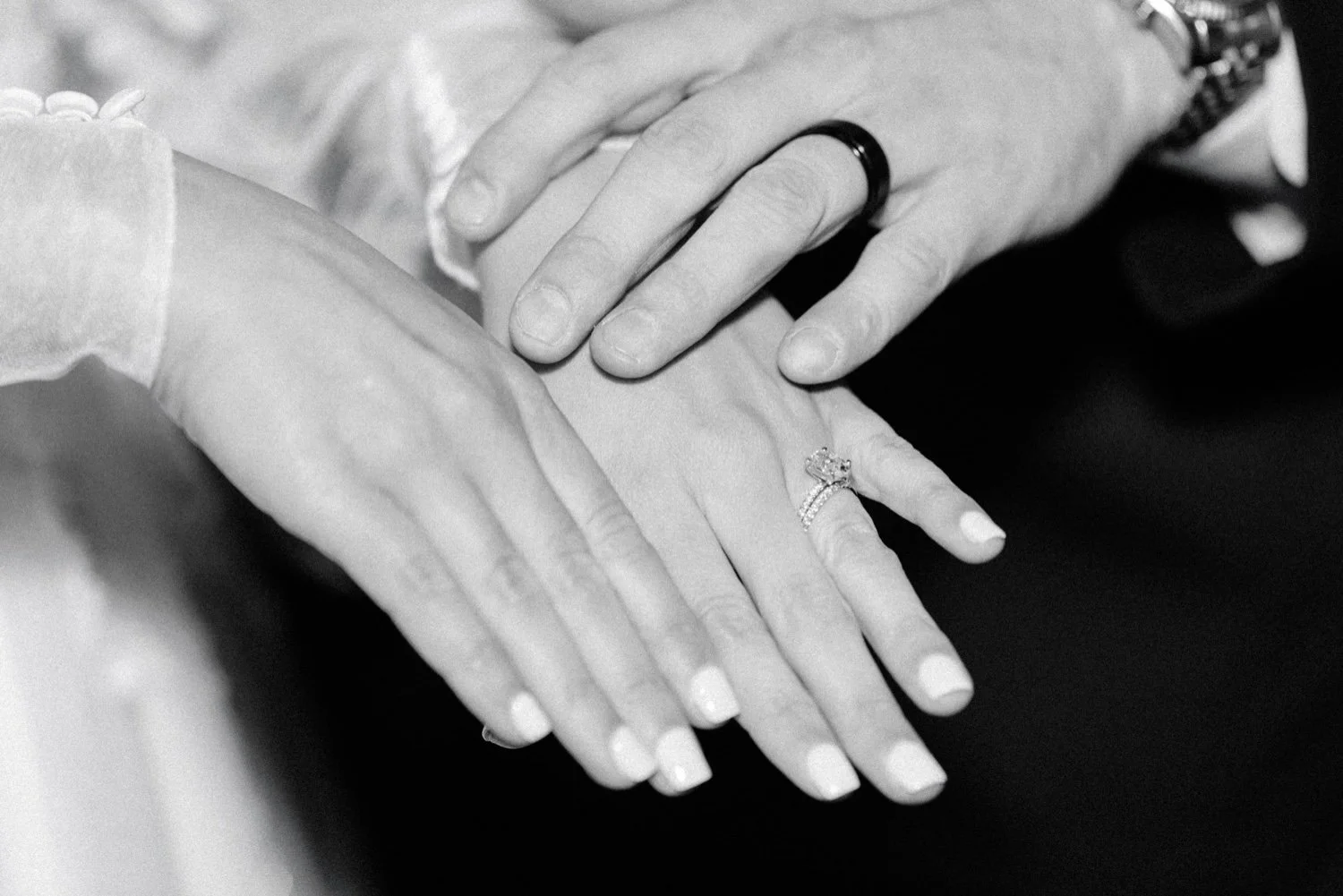  photo of bride and grooms hands showing their wedding rings 