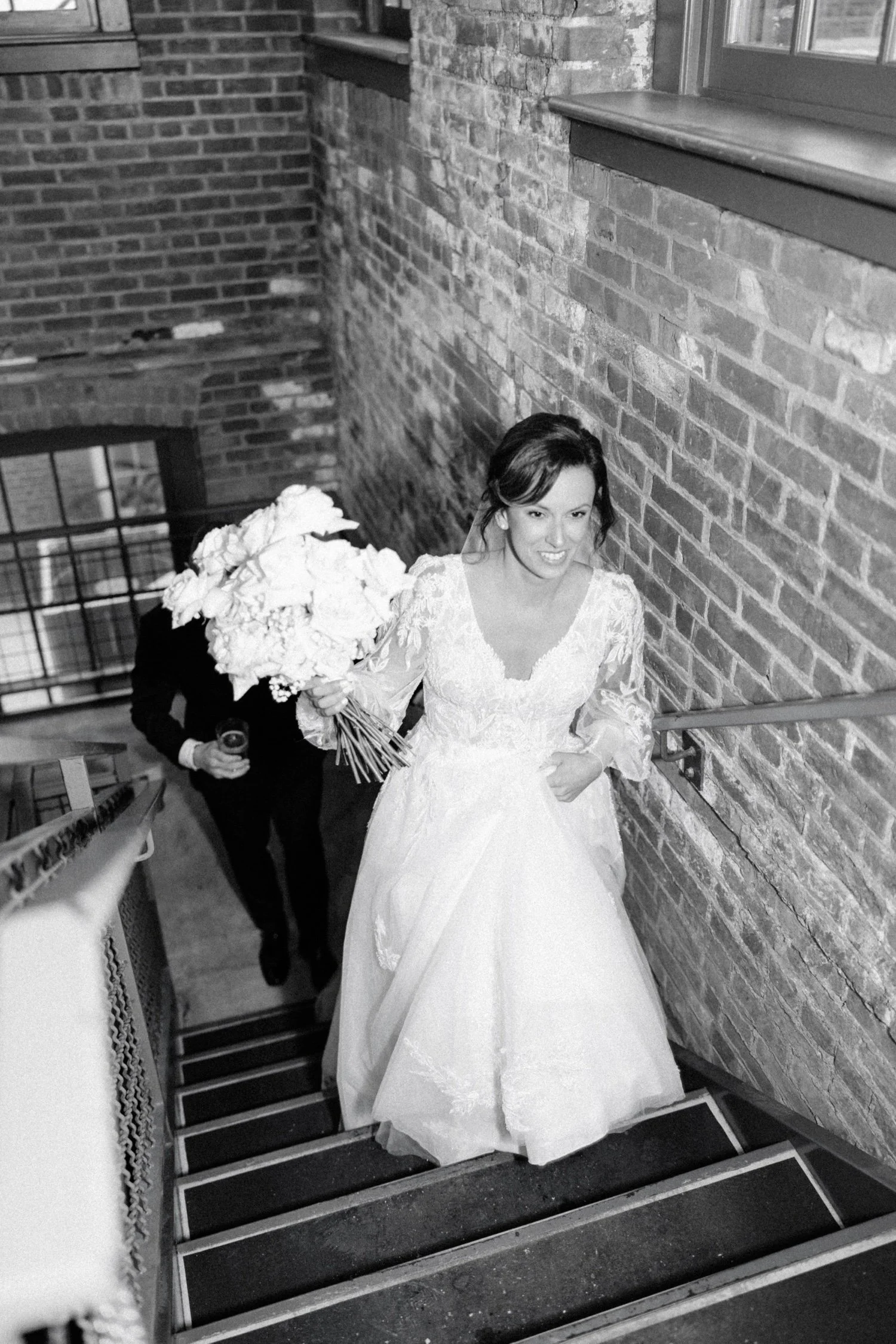 black and white flash photograph of bride walking up stairs on her winter wedding day at city winery hudson valley 