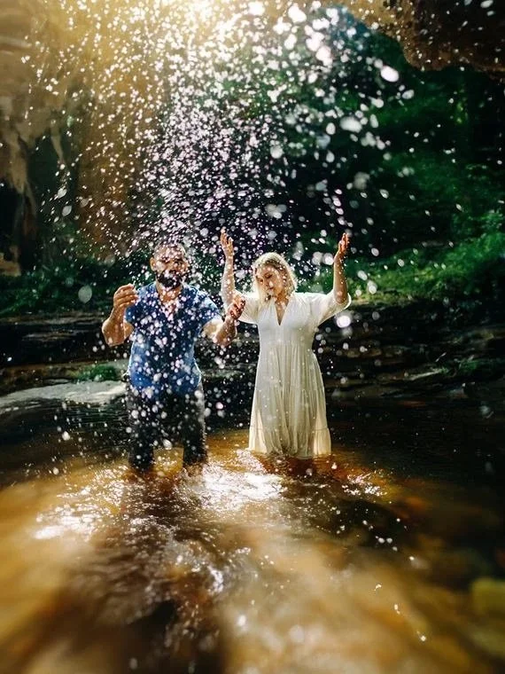 Engaged couple throwing water towards their photographer Caitlinn Mahar-Daniels during their Hudson Valley engagement photo shoot in Minnewaska State Park