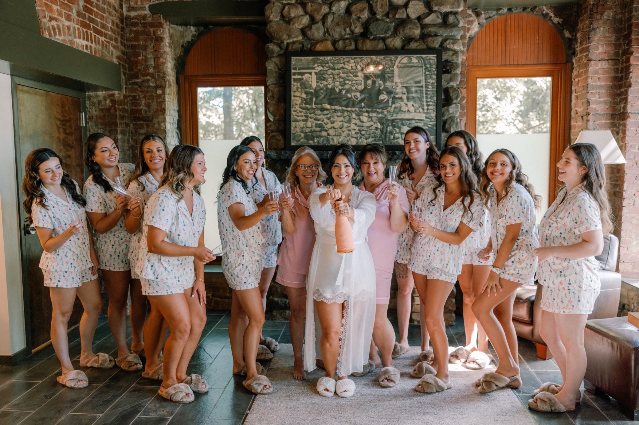 bride with bridesmaids popping champagne at the bridal suite in brotherhood winery 