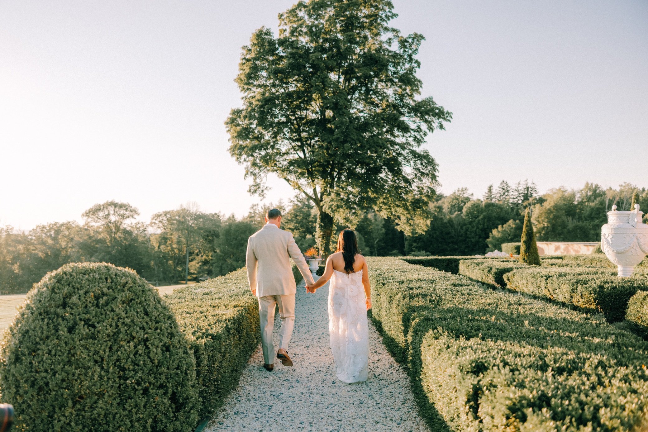  glenmere mansion wedding weekend portraits couple walking in hedge maze 