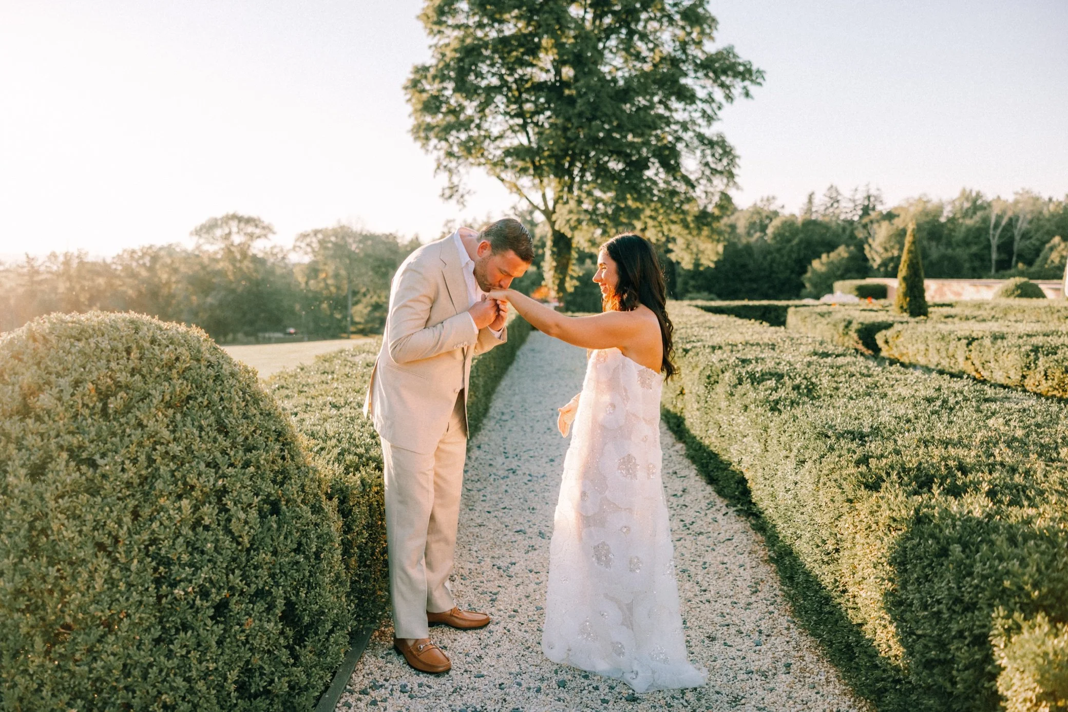  glenmere mansion wedding weekend portraits groom kissing bride on hand 