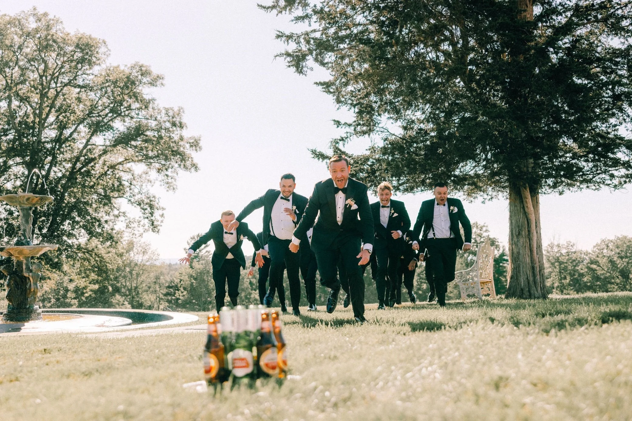  groomsmen running to bottles of beer at glenmere mansion 