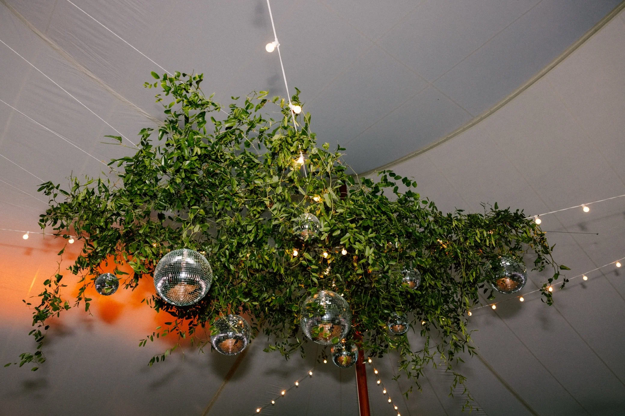  disco balls and greenery at buttermilk falls tented wedding reception 