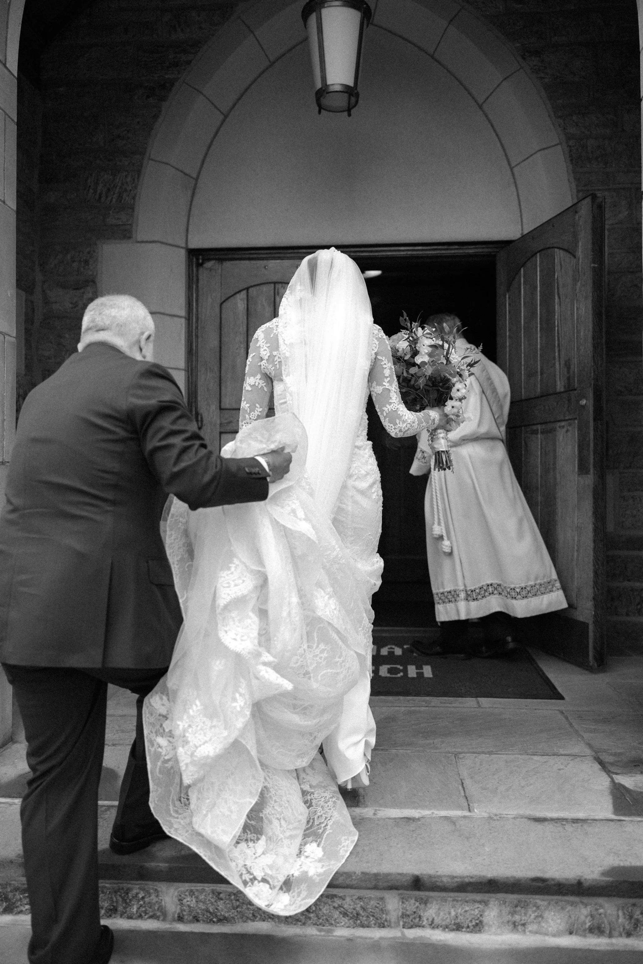  bride and father walking into church for her intimate wedding ceremony in the hudson valley 