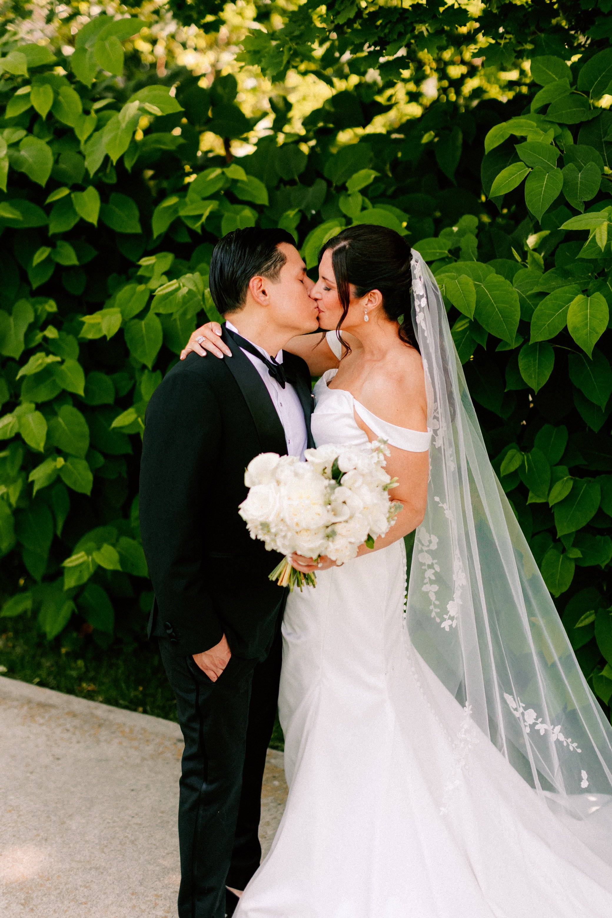 the round wedding photograph of couple kissing outside  