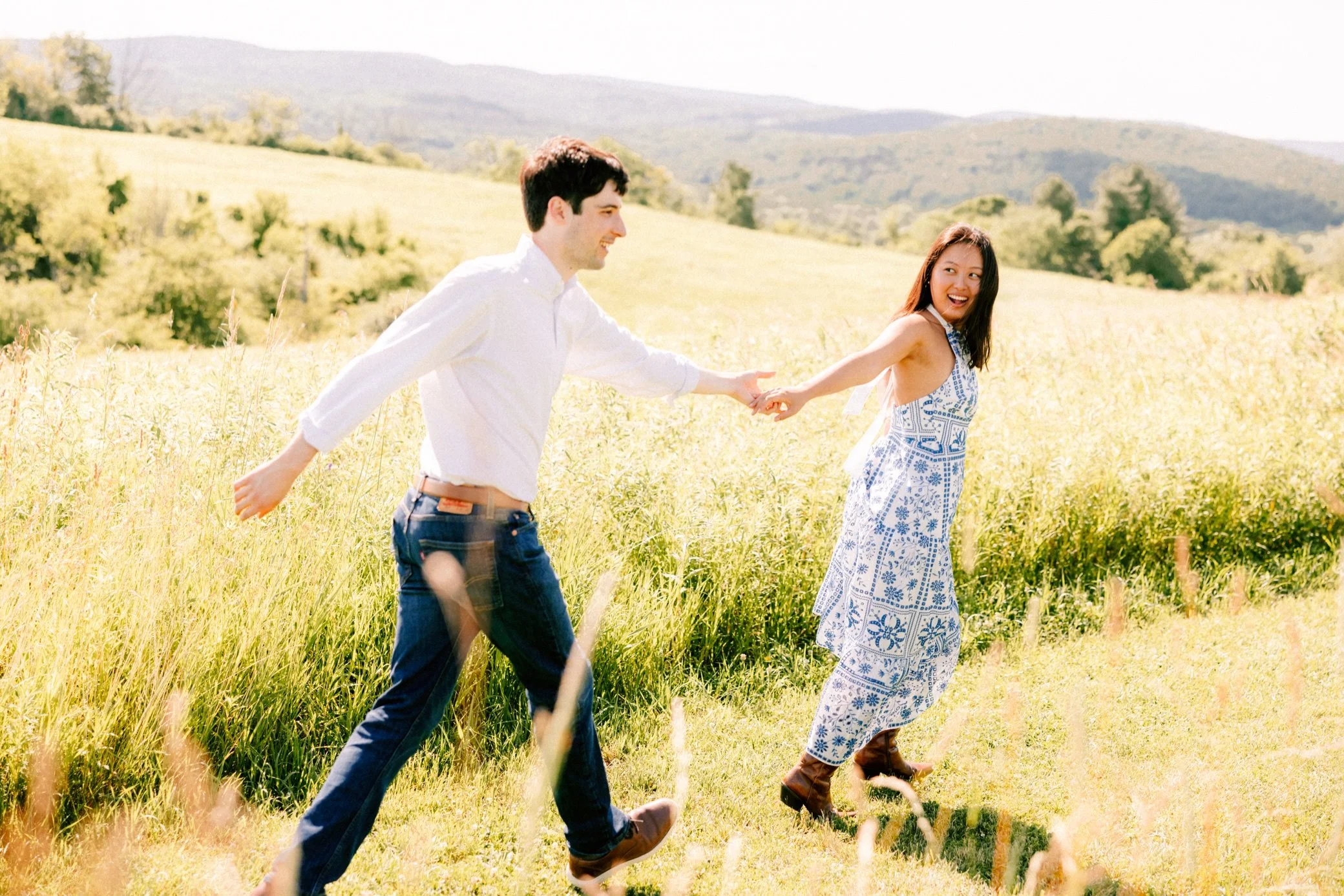  engaged couple run through summer field at Ooms - Columbia Land Conservancy 