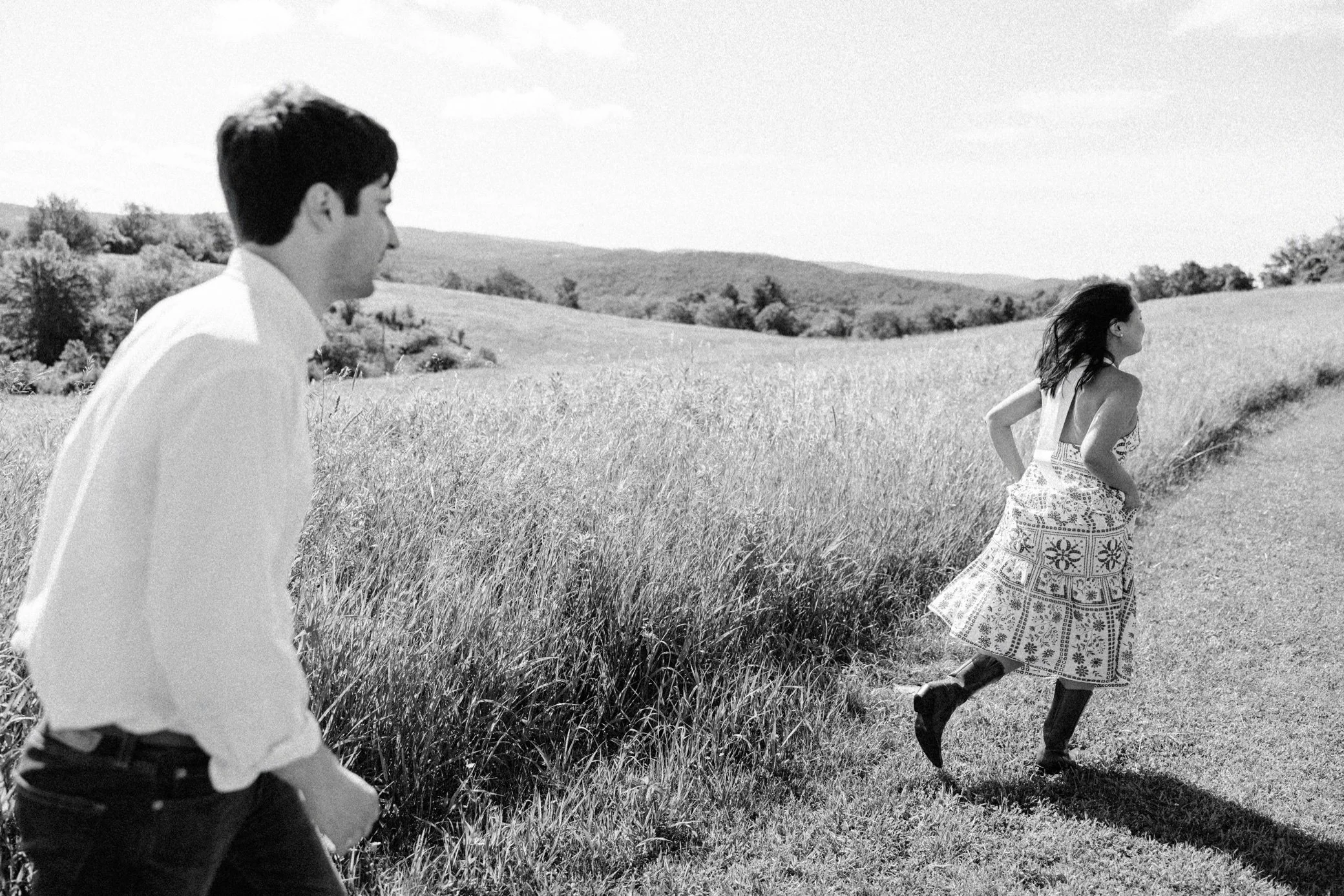  engaged couple run though field during their pride and prejudice inspired hudson valley engagement photography shoot 