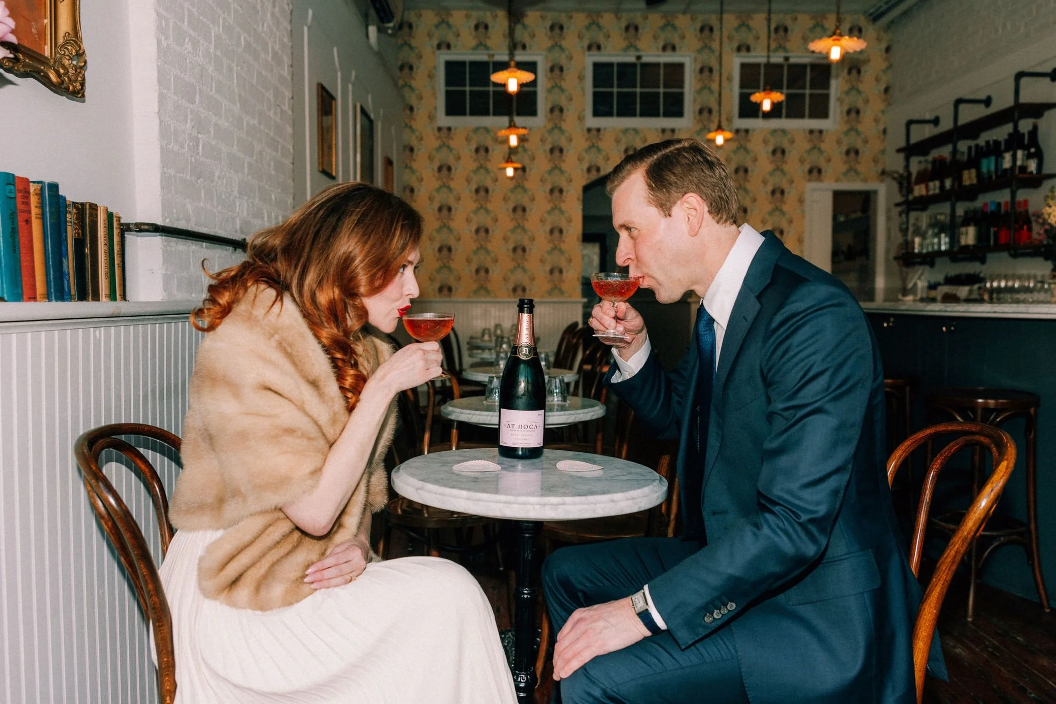  engaged couple share some sparkling rose during their engagement shoot at brunette wine bar in kingston, ny 