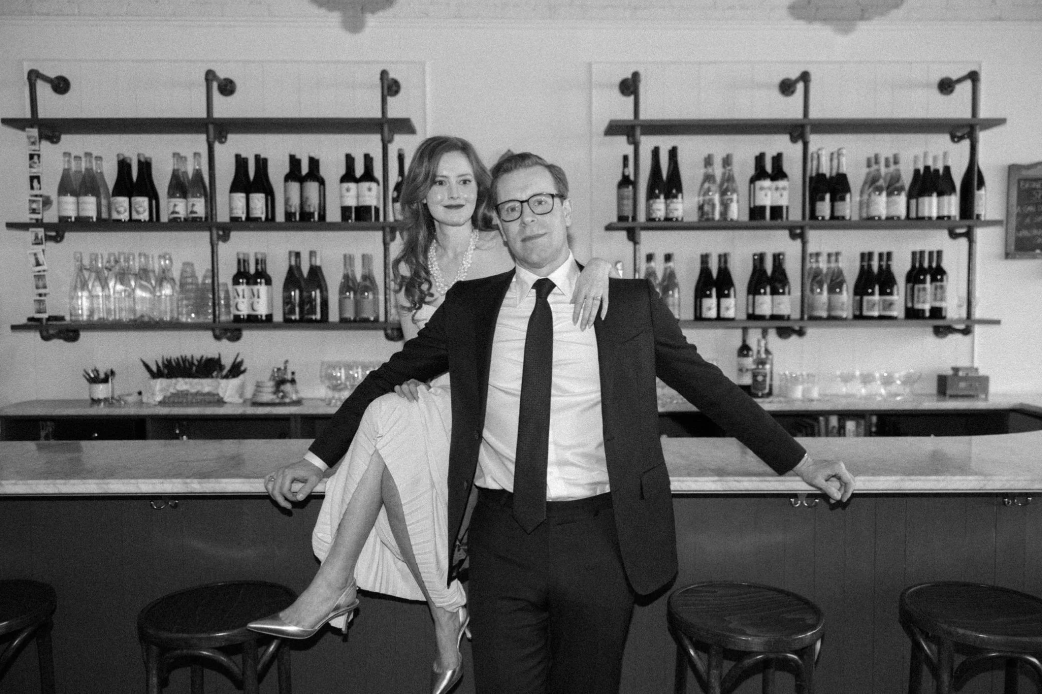  engaged couple pose on bar during their indoor engagement photography shoot at brunette in kingston, ny 