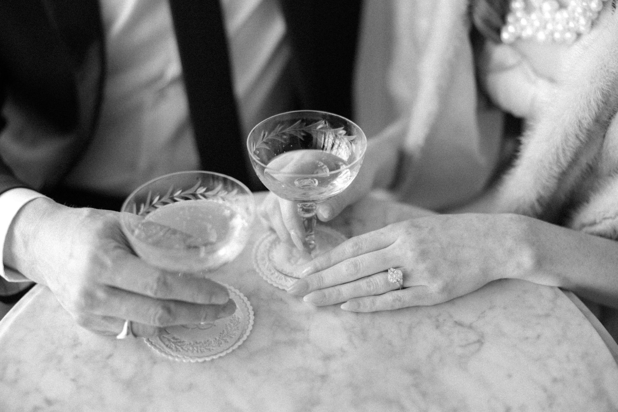  engaged couple hold champagne coupes at brunette wine bar in kingston, ny 