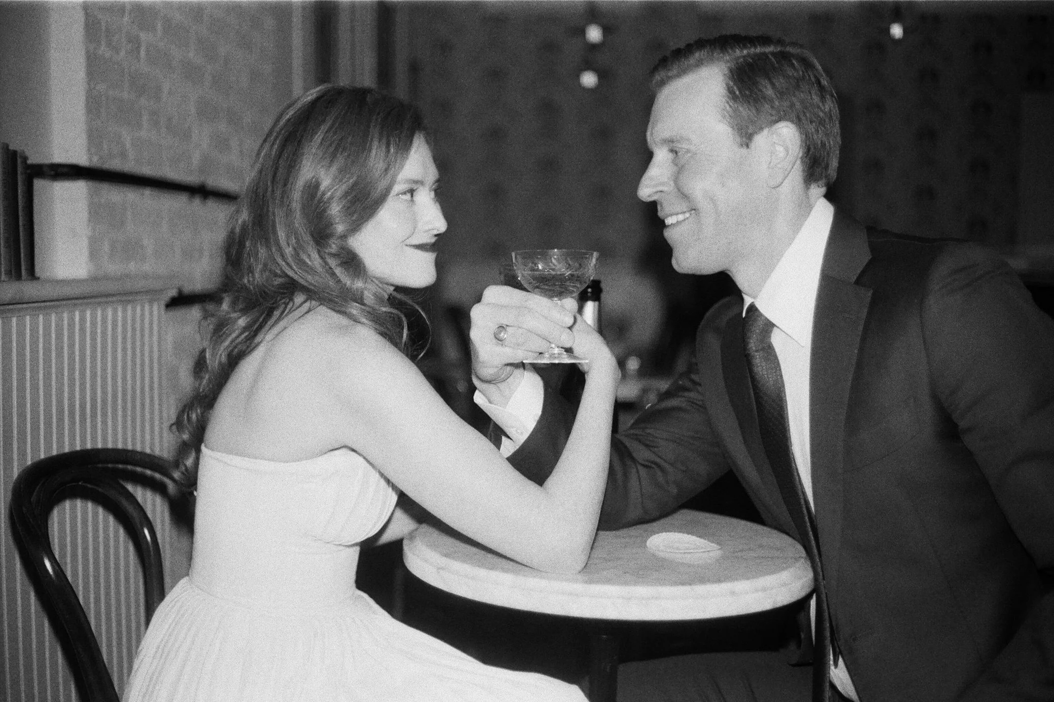  engaged couple photographed on film enjoying wine during their indoor hudson valley engagement shoot at brunette in kingston, ny 