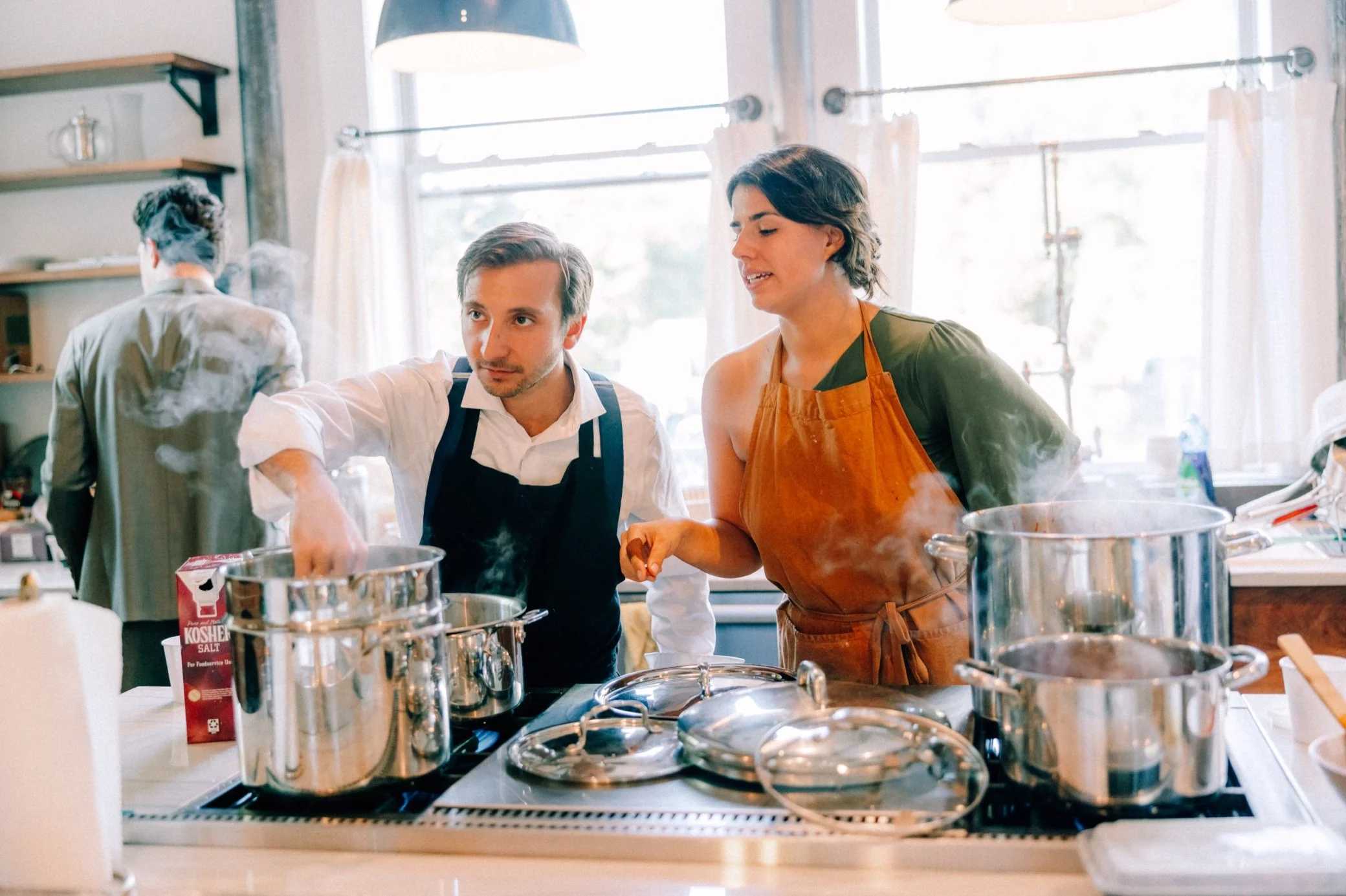  wedding guests preparing intimate pasta dinner in the kitchen of the The Yard mansion 