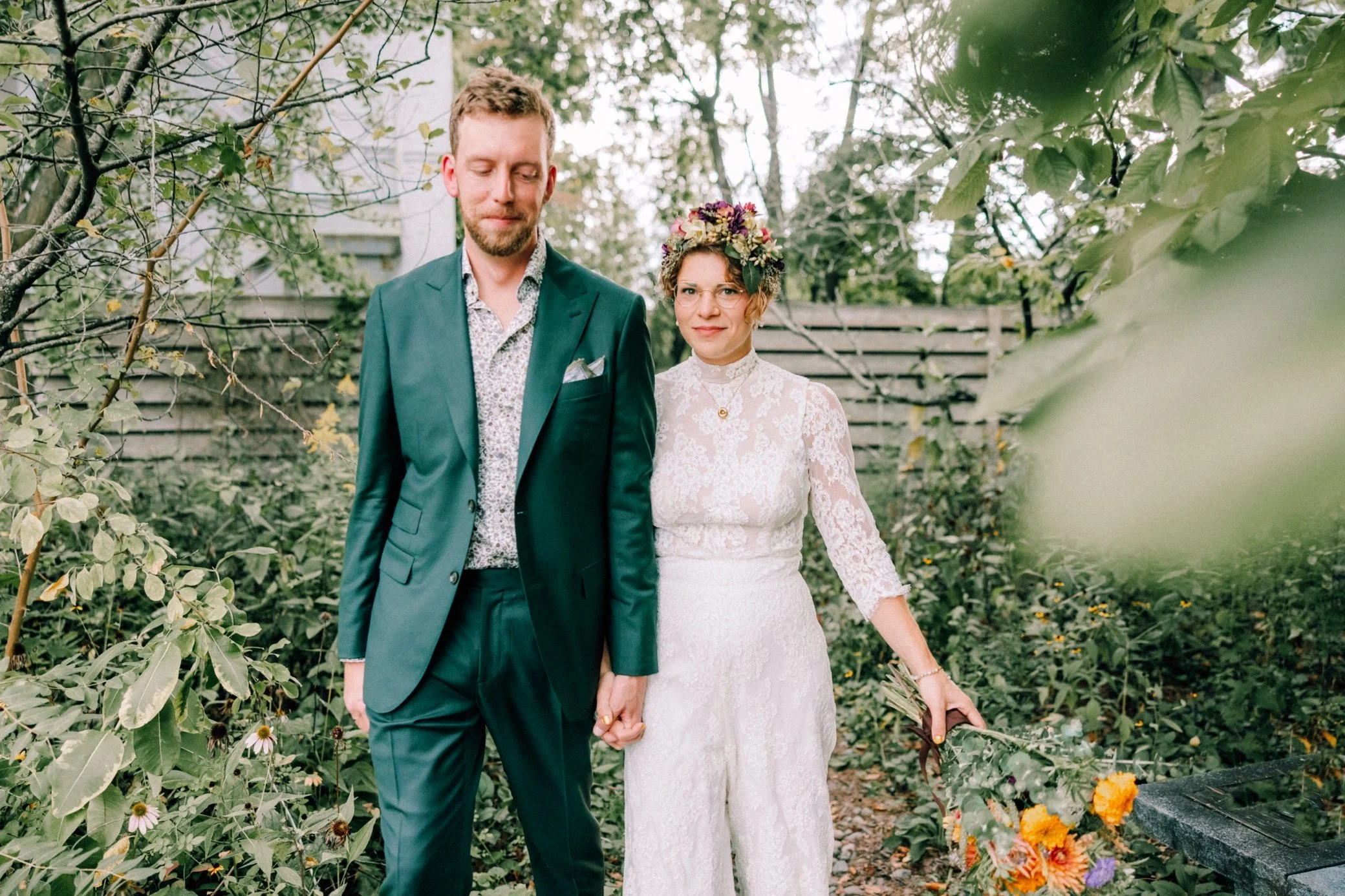  bride and groom hold hands and walk through foliage at the yard wedding venue in beacon, ny 