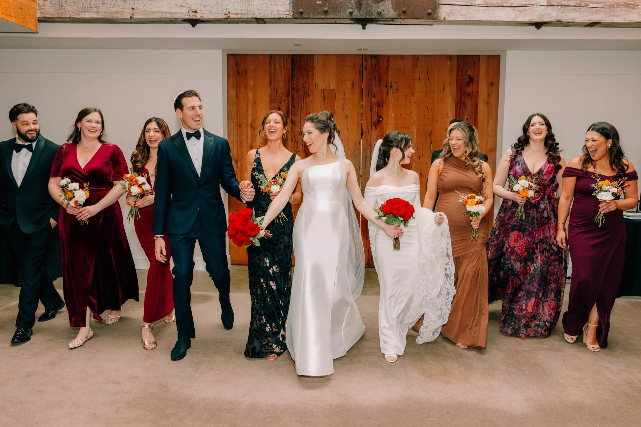  wedding party walking and laughing inside the roundhouse 