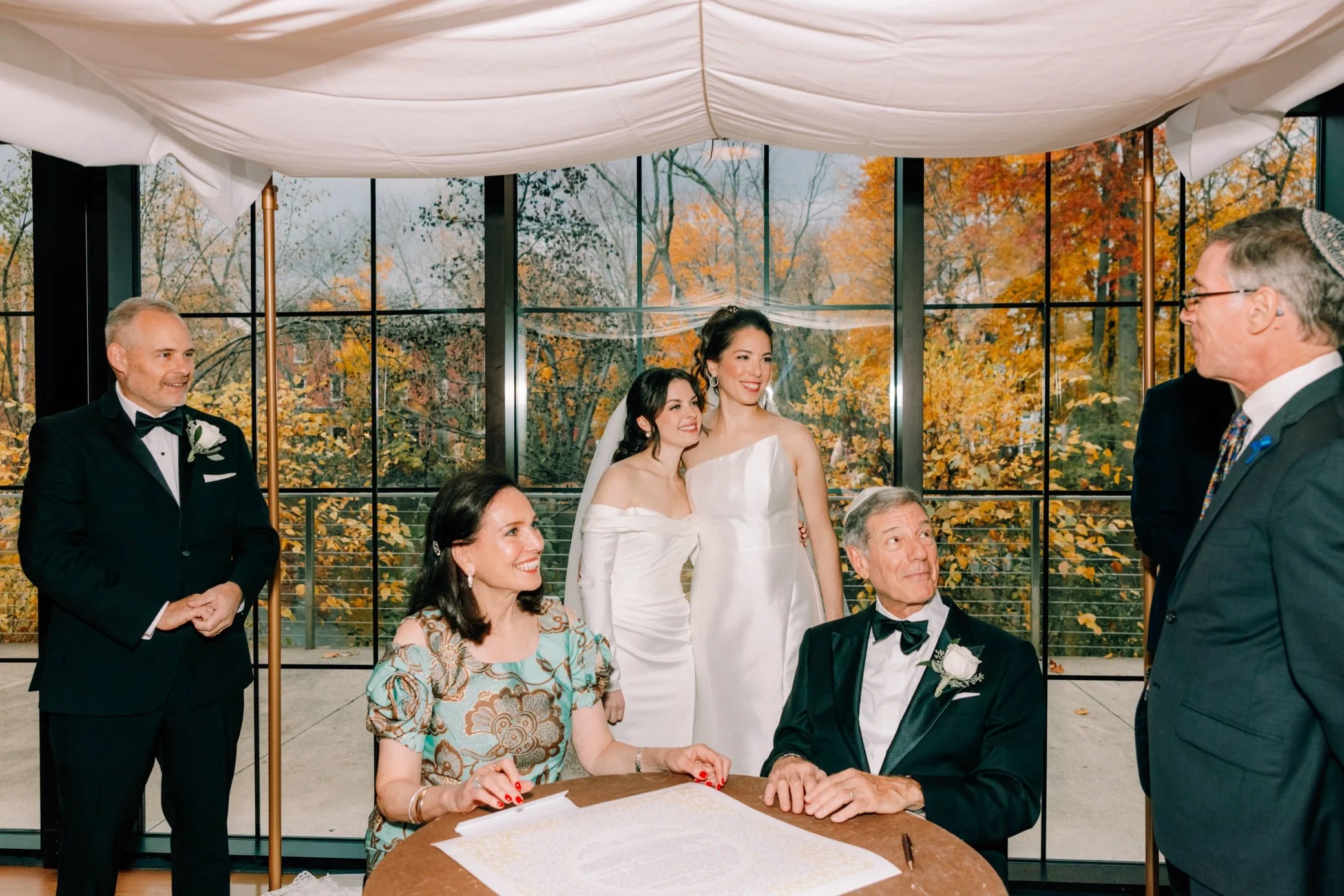  bride’s parents smile at rabbi while signing ketubah at the roundhouse 