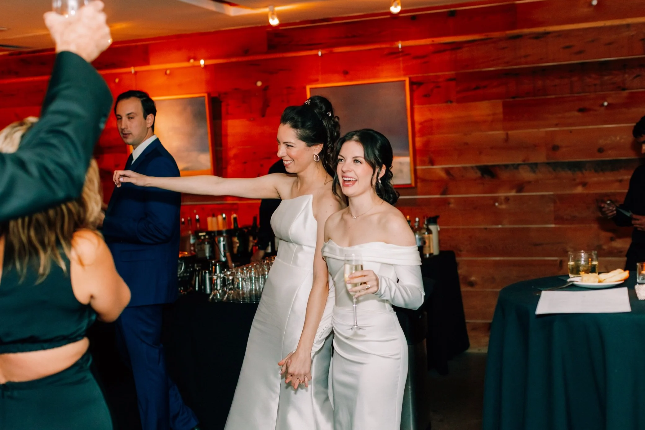  brides enter cocktail hour holding hands inside at the roundhouse 