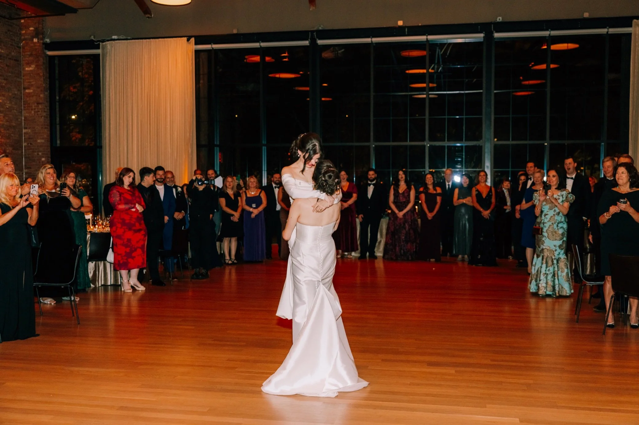  bride do a lift during their first dance with guests looking on at the roundhouse 