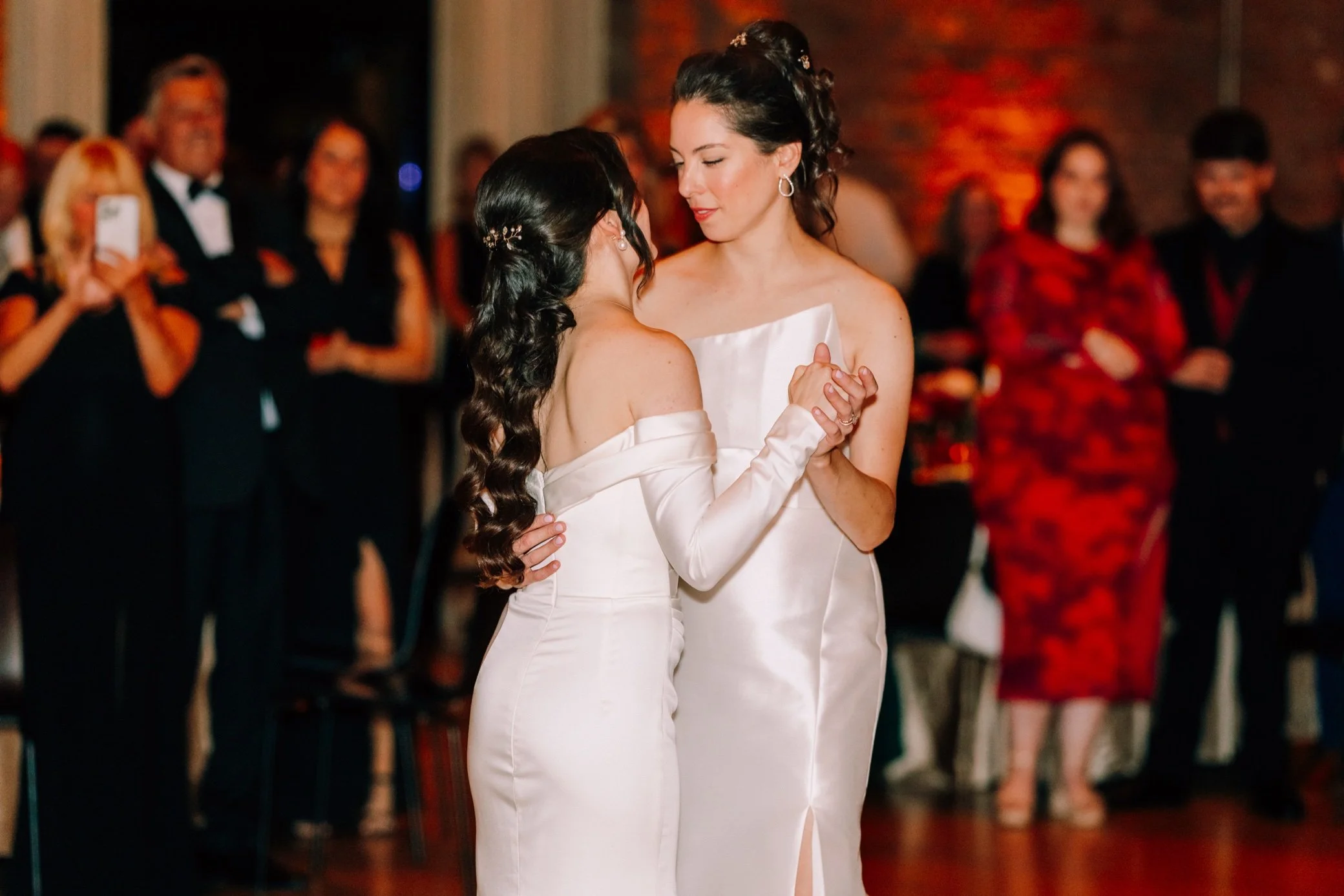  brides look at each other and embrace during their first dance at the roundhouse  