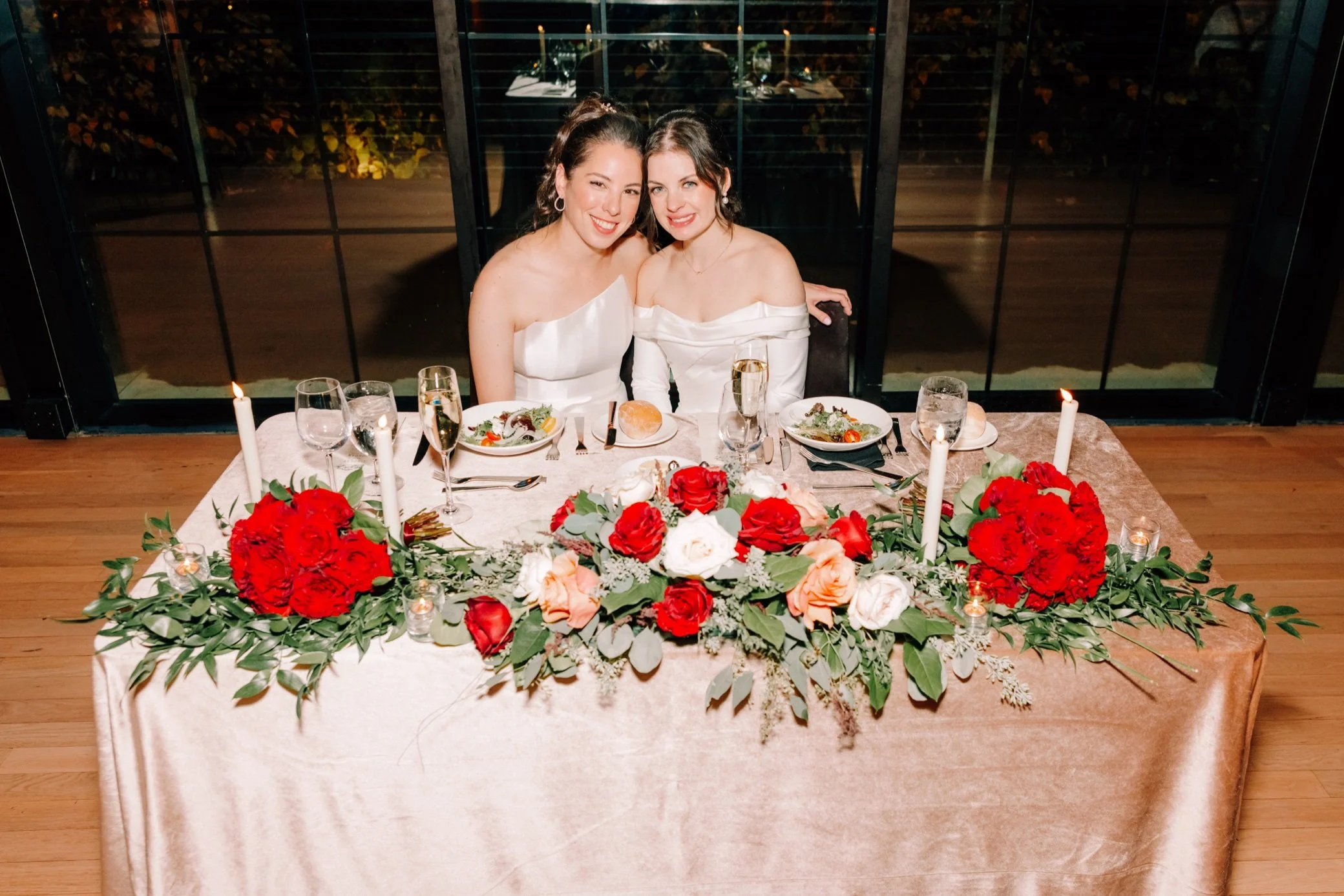  brides sitting at sweetheart table at the roundhouse 