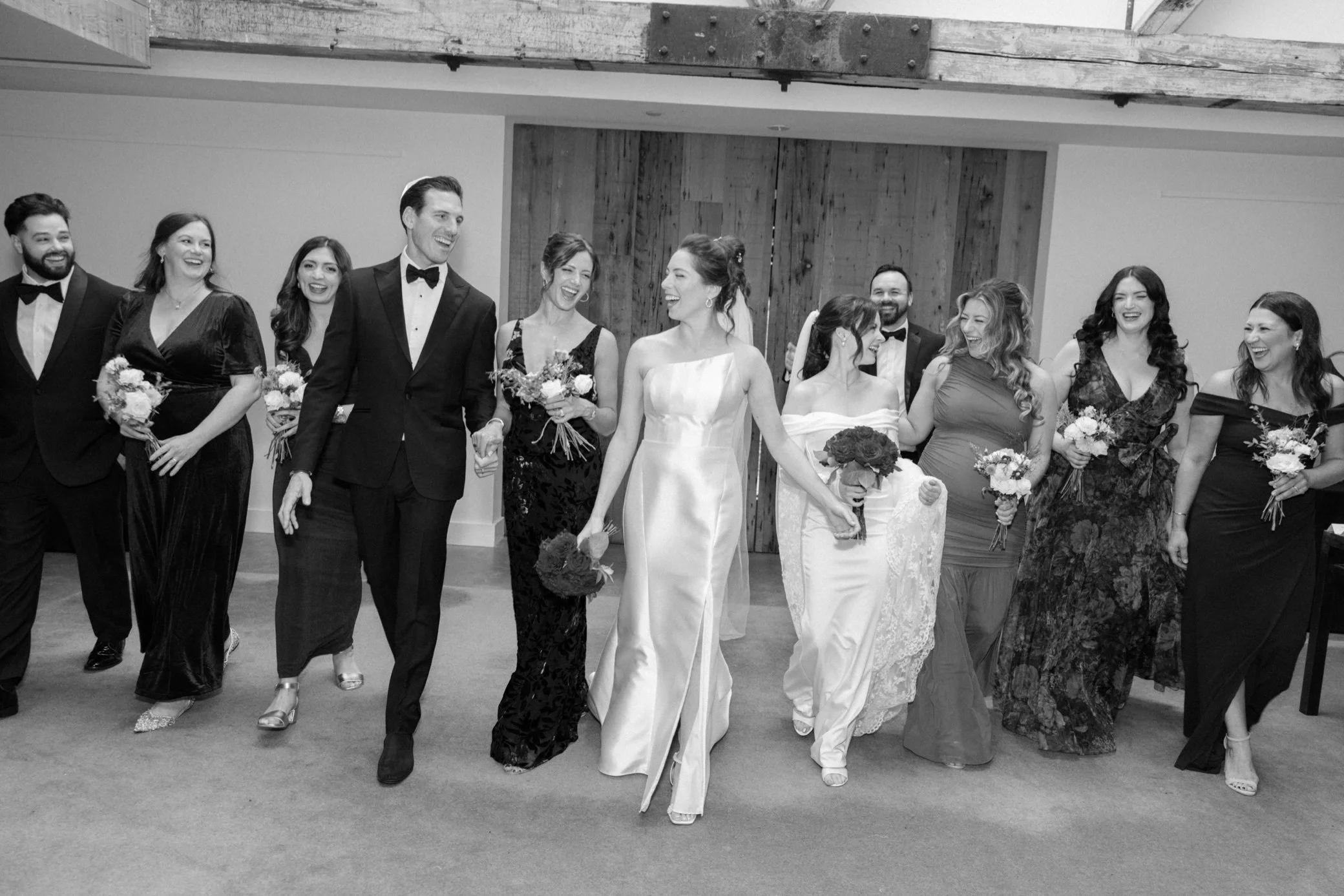  wedding party walks in front of barn doors at the roundhouse 