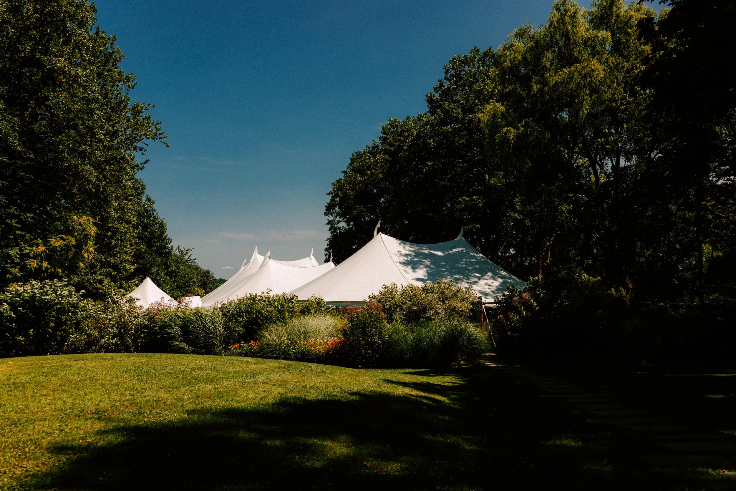 photograph of wedding tents with lush greenery on the property of Buttermilk Falls Inn and Spa