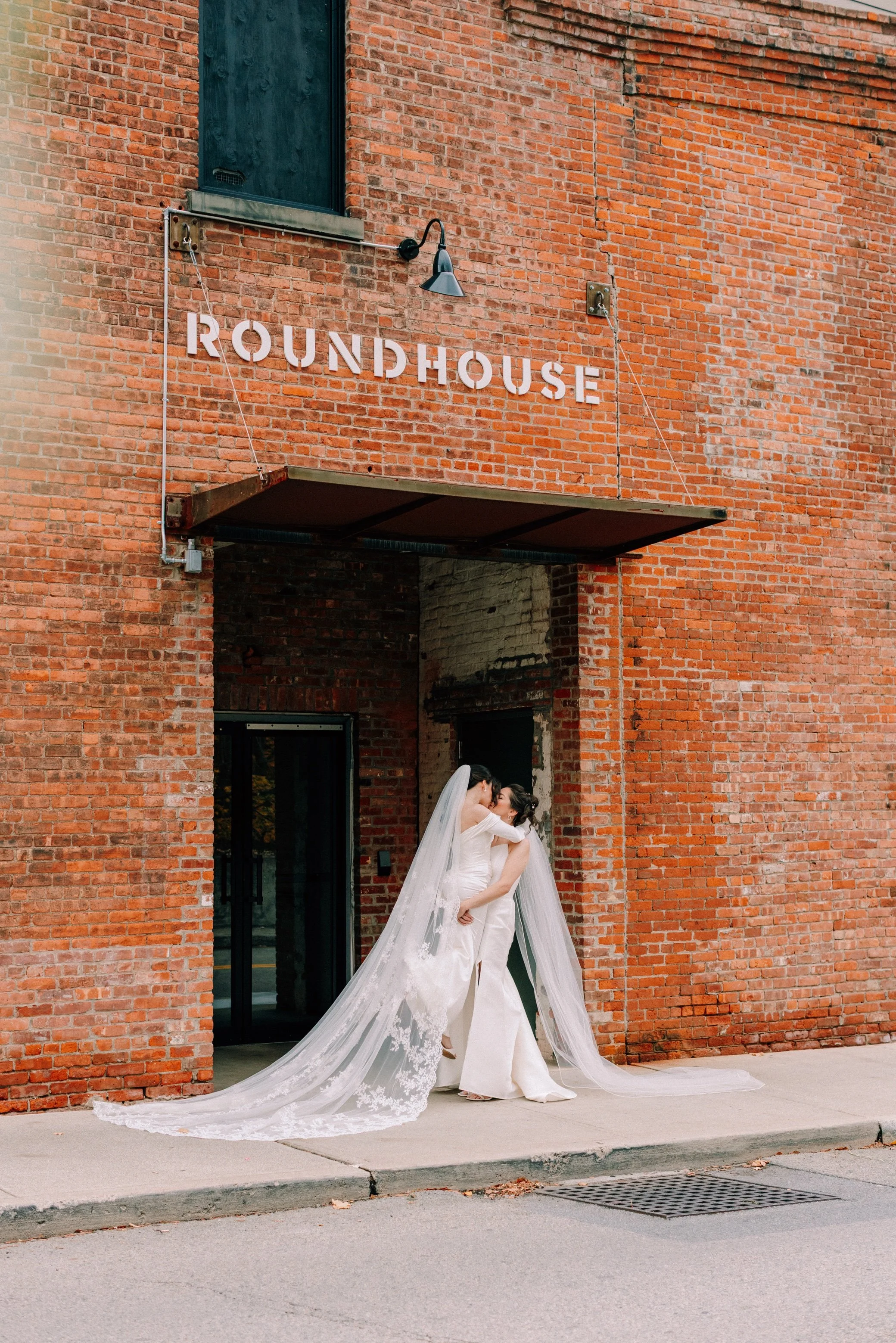 brides in front of the roundhouse sign in beacon, ny