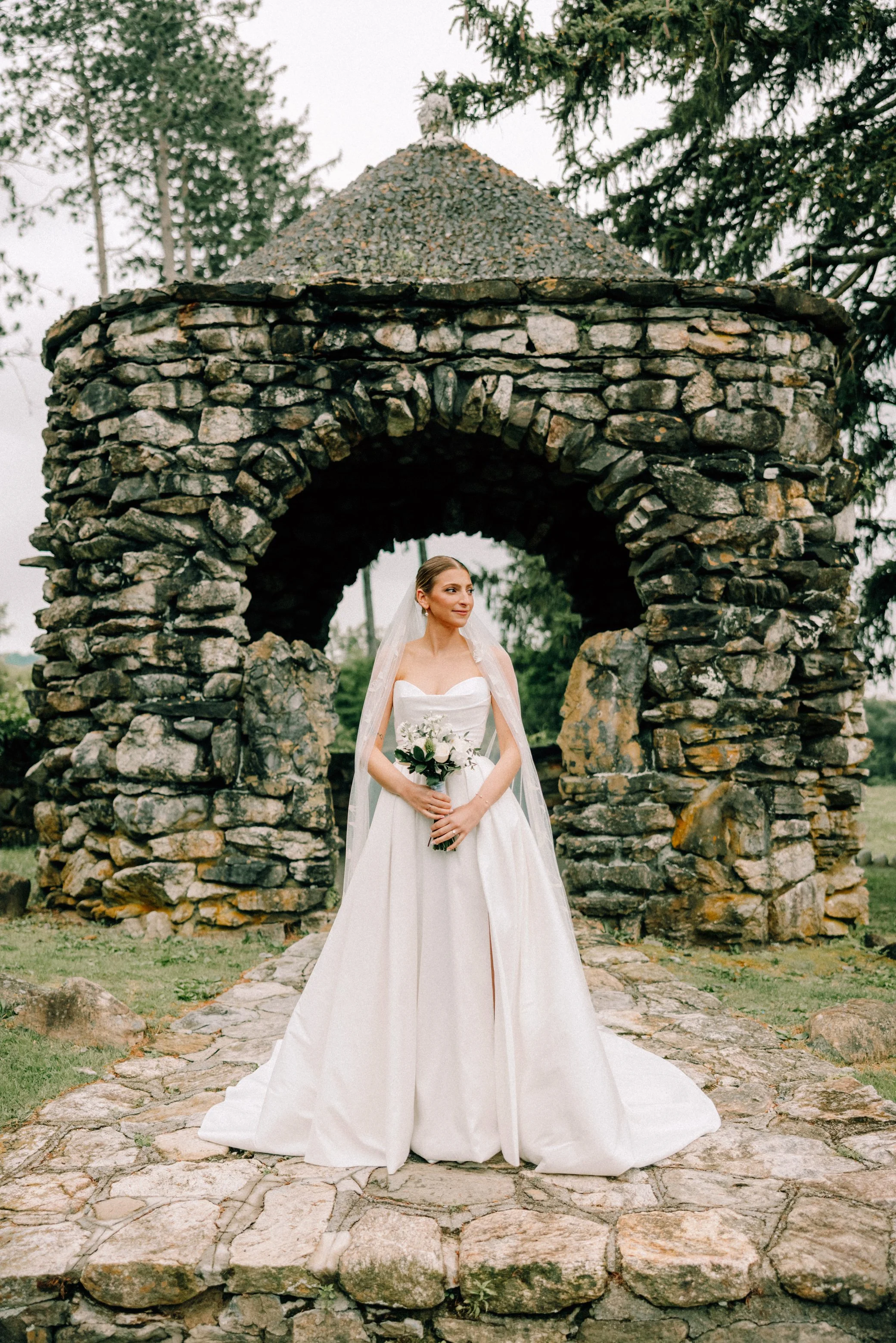 bride looks to her left while holding her bouquet on her wedding day at the garrison